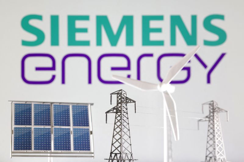 Miniatures of windmill, solar panel and electric pole are seen in front of Siemens Energy logo in this illustration taken January 17, 2023.