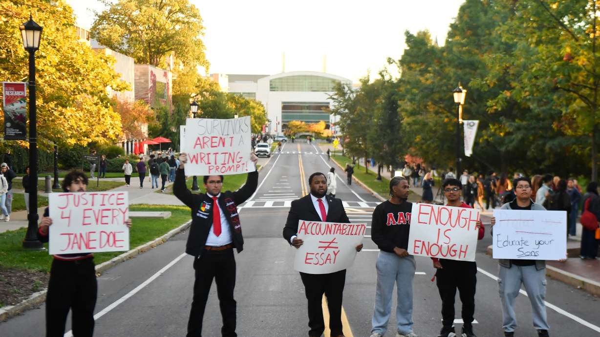 Demonstrators hold signs during a protest against Cornell University's handling of the 2024 fraternity-house gang rape allegations at the campus, Monday in Ithaca, N.Y.