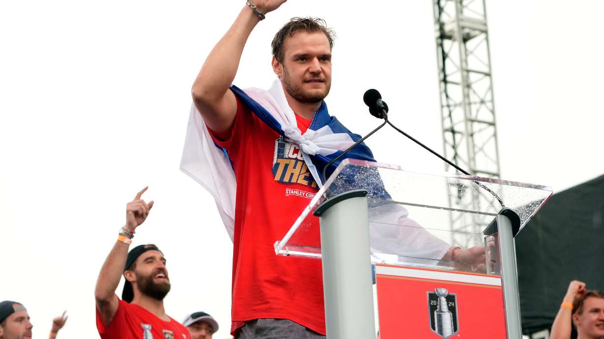 FILE - Florida Panthers' Aleksander Barkov, front, gestures while speaking during an NHL hockey rally and parade to celebrate the NHL hockey team winning the Stanley Cup, Sunday, June 30, 2024, in Fort Lauderdale, Fla..