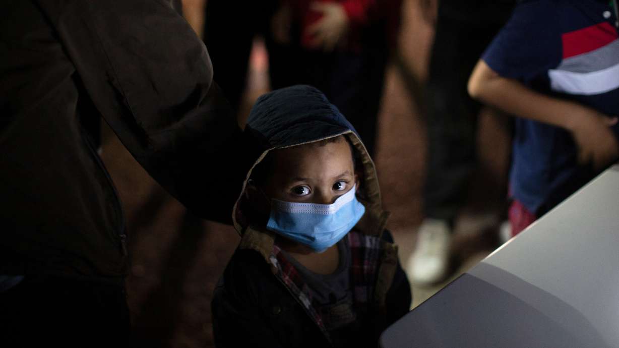 An unaccompanied minor looks up as he waits to answer questions from a U.S. Border Patrol agent at an intake site after he was smuggled on an inflatable raft across the Rio Grande River, March 24, 2021, in Roma, Texas.