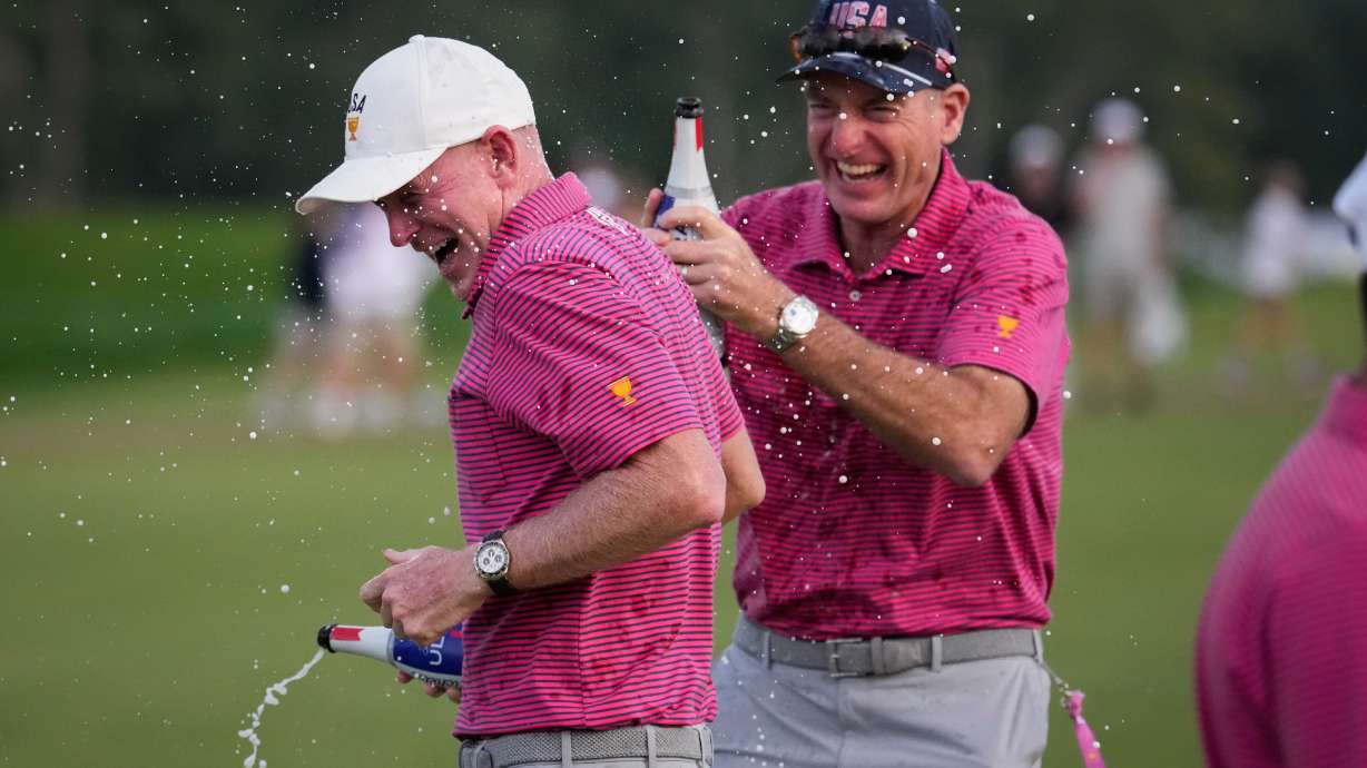 USA team captain Brandt Snedeker celebrates with assistant Jim Furyk fter their Presidents Cup golf tournament win against the International team at Medinah Country Club, Sunday, Sept. 27, 2026, in Medinah, Ill.