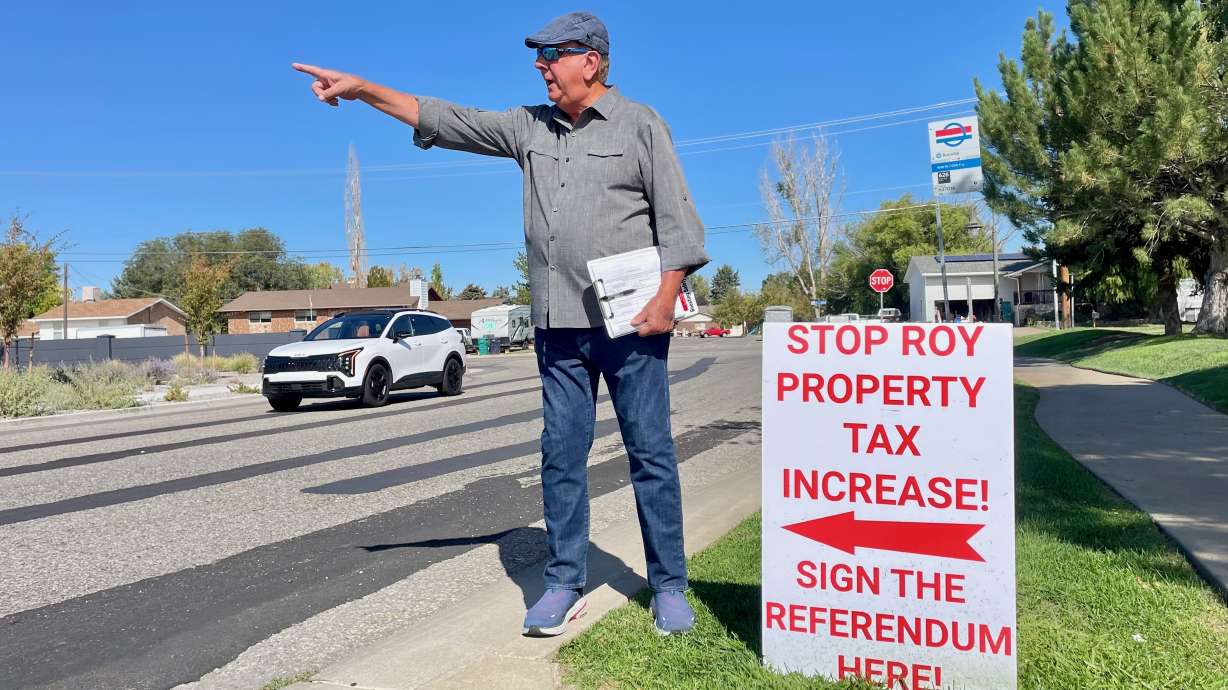 Goeffrey Cox gathered signatures on Tuesday as part of the drive to force a vote on whether to keep the 34.25% property tax hike approved by Roy leaders. He was collecting signatures outside the state liquor store in Roy.