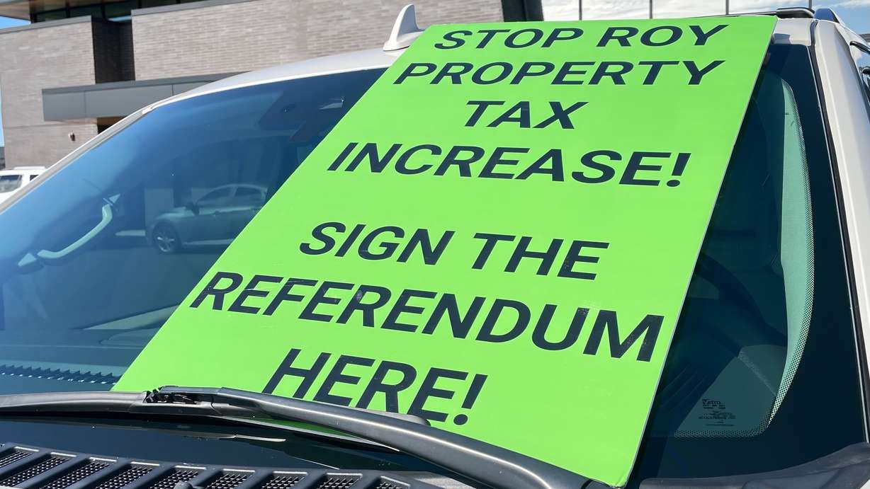 Goeffrey Cox and others are in the final days of gathering signatures as part of the drive to force a vote on whether to keep the 34.25% property tax hike approved by Roy leaders. The photo shows a sign on his car in Roy on Tuesday.