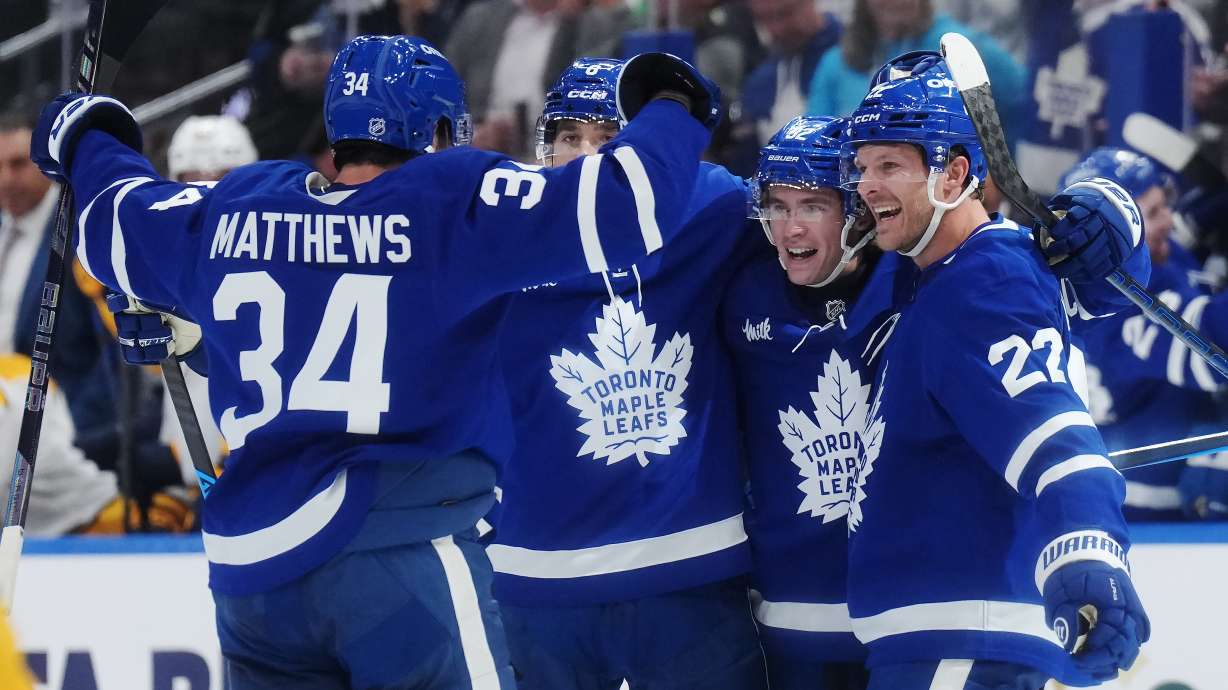 Toronto Maple Leafs' Gavin McKenna (second right) celebrates his goal against the Nashville Predators with Auston Matthews, left to right, Chris Tanev and Jake McCabe during the second period of an NHL hockey game in Toronto, Tuesday, Oct. 6, 2026.