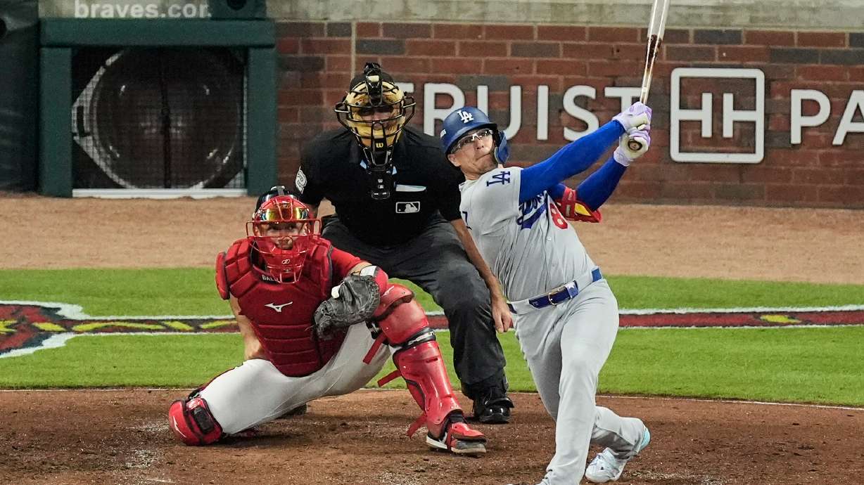 Los Angeles Dodgers' Enrique Hernández follows through on a two-run home run as Atlanta Braves catcher Drake Baldwin (30) and umpire James Hoye look on during the fourth inning in Game 3 of baseball's National League Division Series, Tuesday, Oct. 6, 2026, in Atlanta.