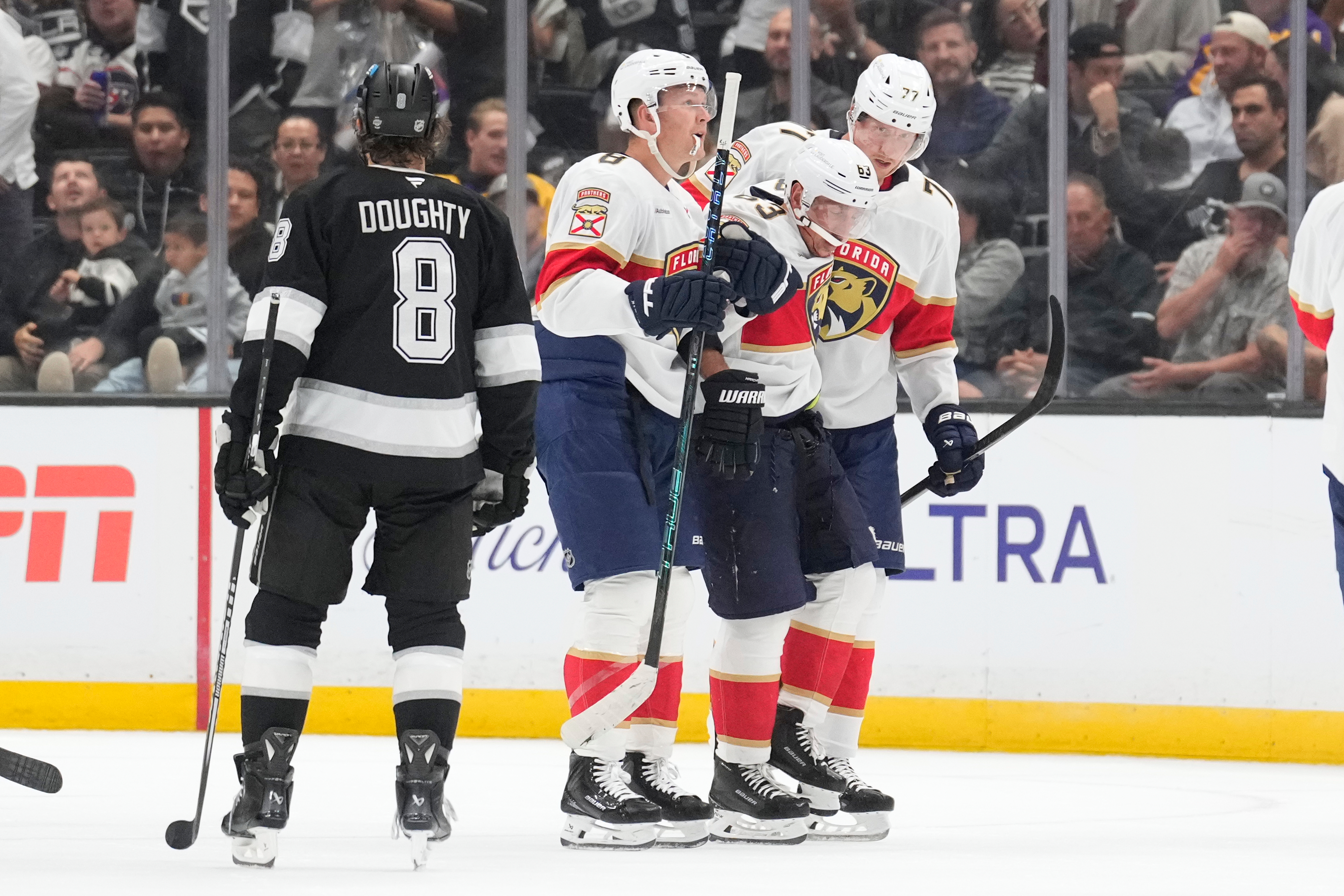 Florida Panthers left wing Brad Marchand, second from right, is helped off the ice by left wing Brady Tkachuk, second from left, and defenseman Niko Mikkola after he was injured as Los Angeles Kings defenseman Drew Doughty looks on during the second period of an NHL hockey game Tuesday, Oct. 6, 2026, in Los Angeles. 