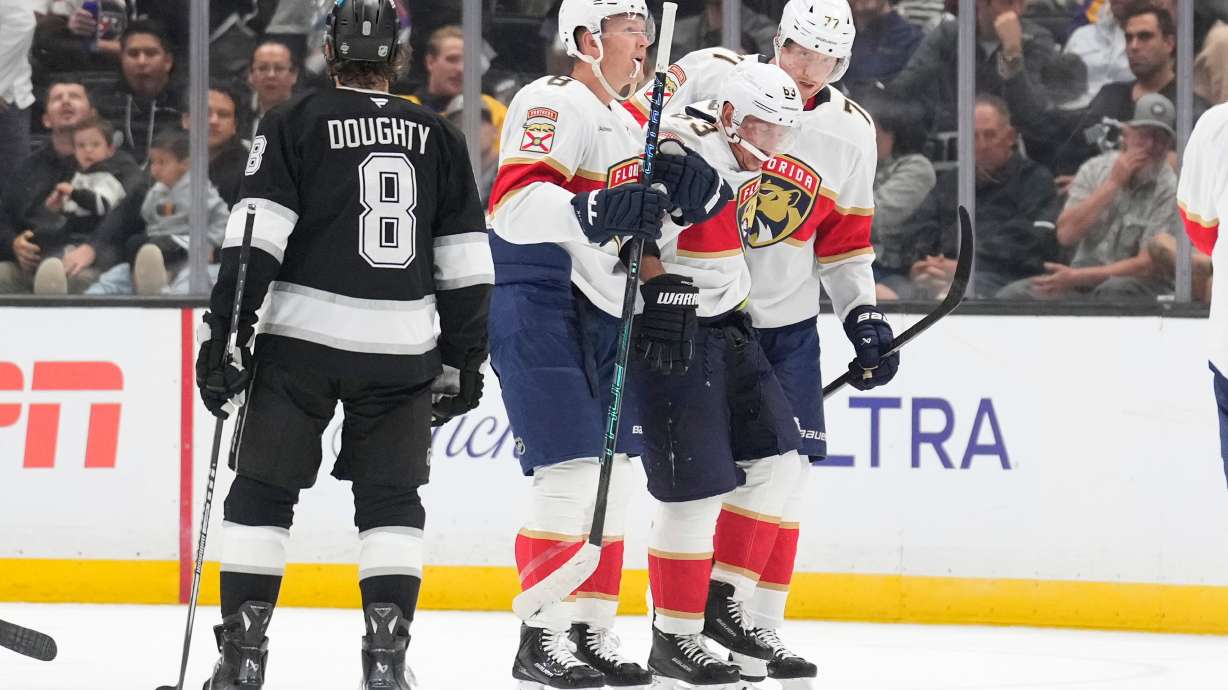 Florida Panthers left wing Brad Marchand, second from right, is helped off the ice by left wing Brady Tkachuk, second from left, and defenseman Niko Mikkola after he was injured as Los Angeles Kings defenseman Drew Doughty looks on during the second period of an NHL hockey game Tuesday, Oct. 6, 2026, in Los Angeles.