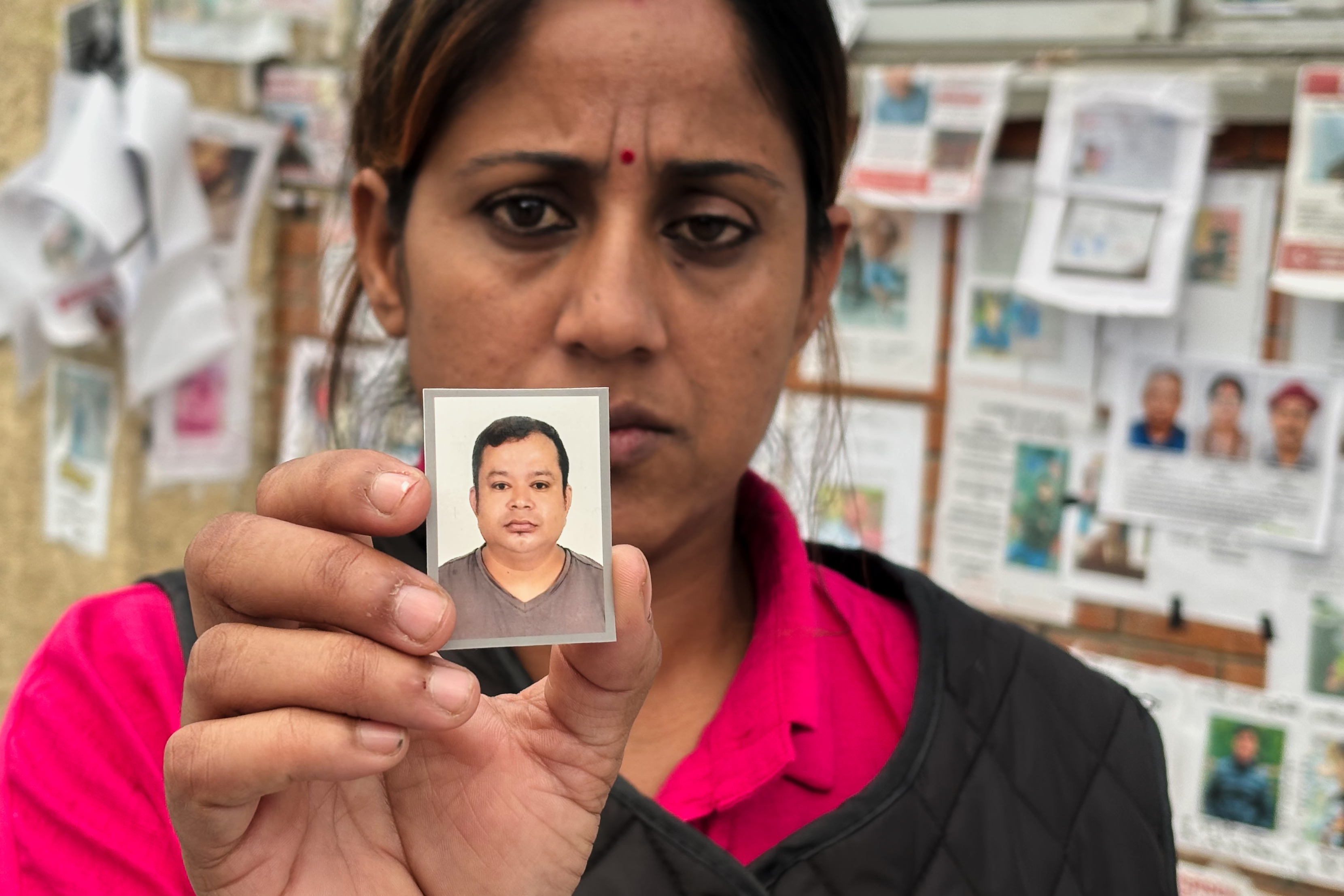 In this photo taken with a smartphone, Usha Khatri shows a photo of her husband Indra Bahadur, who has been missing since last month's flood outside Tribhuvan University Teaching Hospital, in Kathmandu, Nepal, Thursday, Sept. 17.