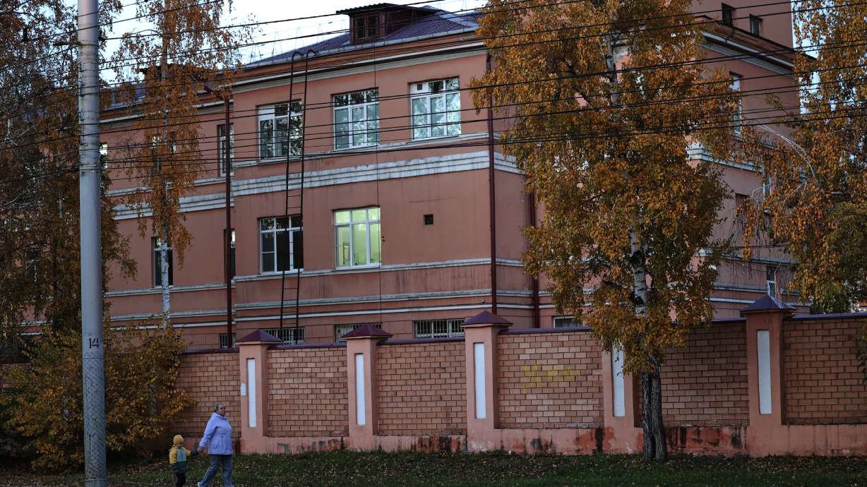 A woman with her child walks past the Irkutsk Anti-Plague Research Institute of Siberia and the Far East in Irkutsk, Russia, on Wednesday.