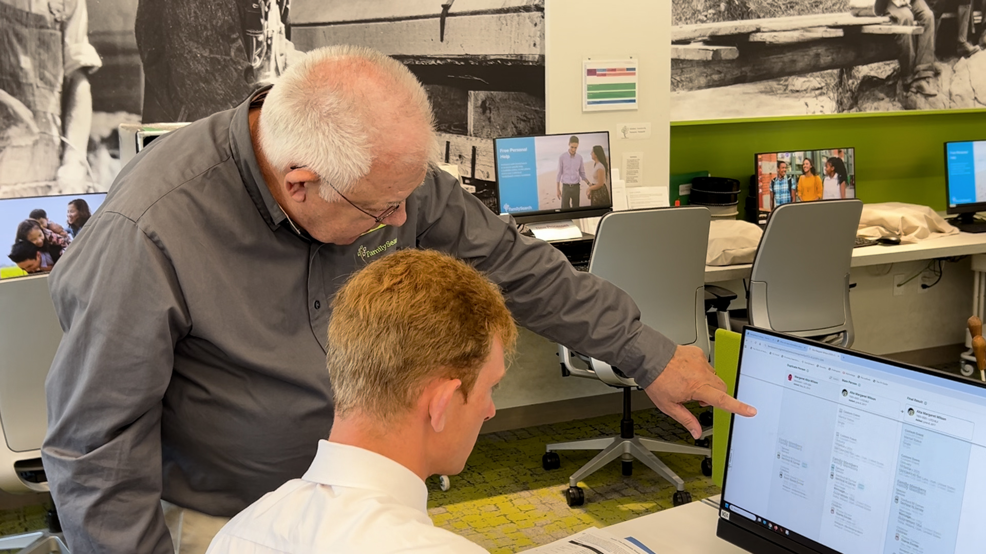 Coordinator Bill Cox helps a person search historical records.