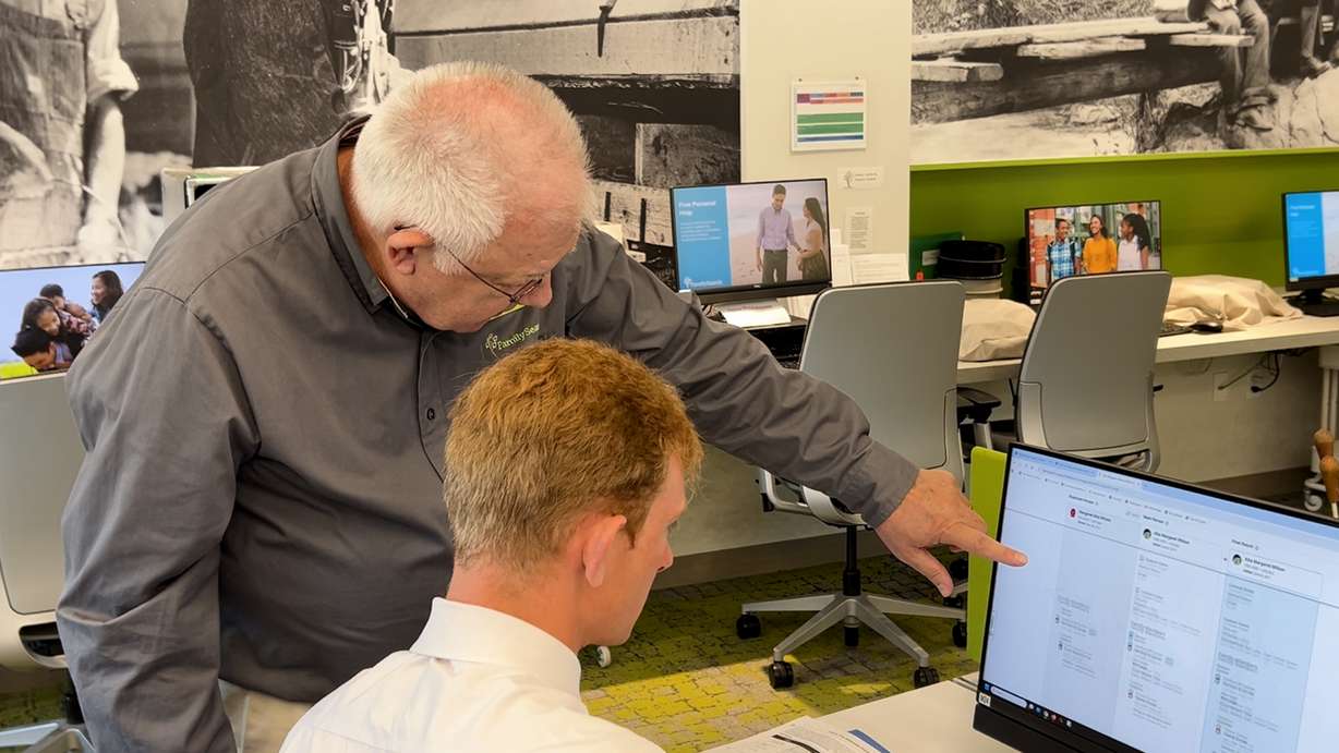 Coordinator Bill Cox helps a person search historical records.