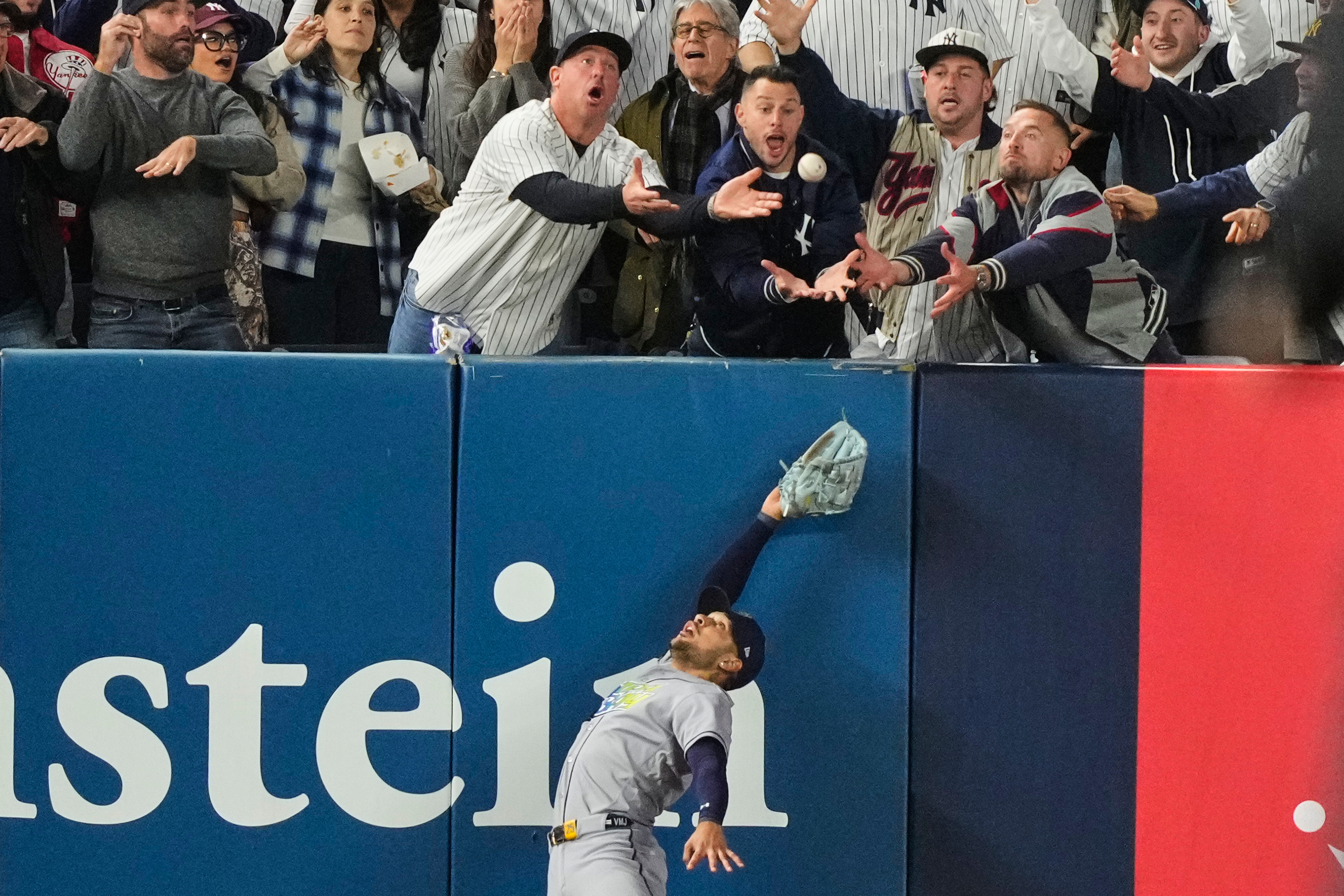 Tampa Bay Rays left fielder Victor Mesa Jr. makes an attempt on a ball interfered with by fans that umpires reviewed and ruled a run-scoring double by New York Yankees' Anthony Volpe during the sixth inning in Game 3 of baseball's American League Division Series, Wednesday, Oct. 7, 2026, in New York.