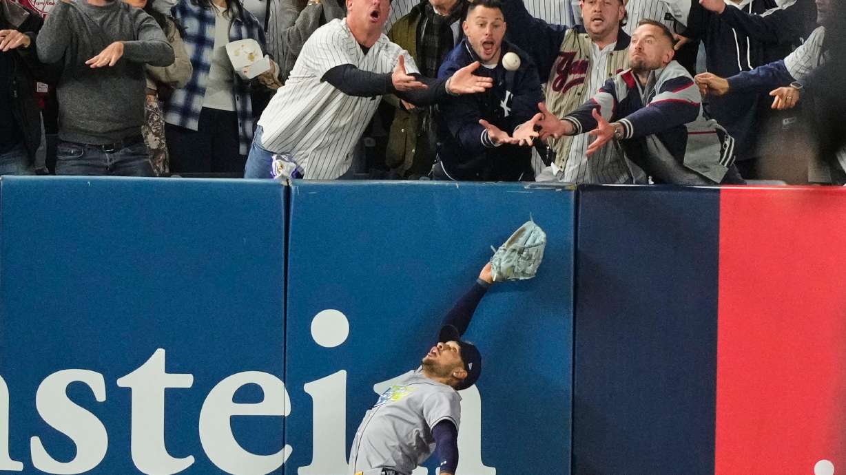 Tampa Bay Rays left fielder Victor Mesa Jr. makes an attempt on a ball interfered with by fans that umpires reviewed and ruled a run-scoring double by New York Yankees' Anthony Volpe during the sixth inning in Game 3 of baseball's American League Division Series, Wednesday, Oct. 7, 2026, in New York.