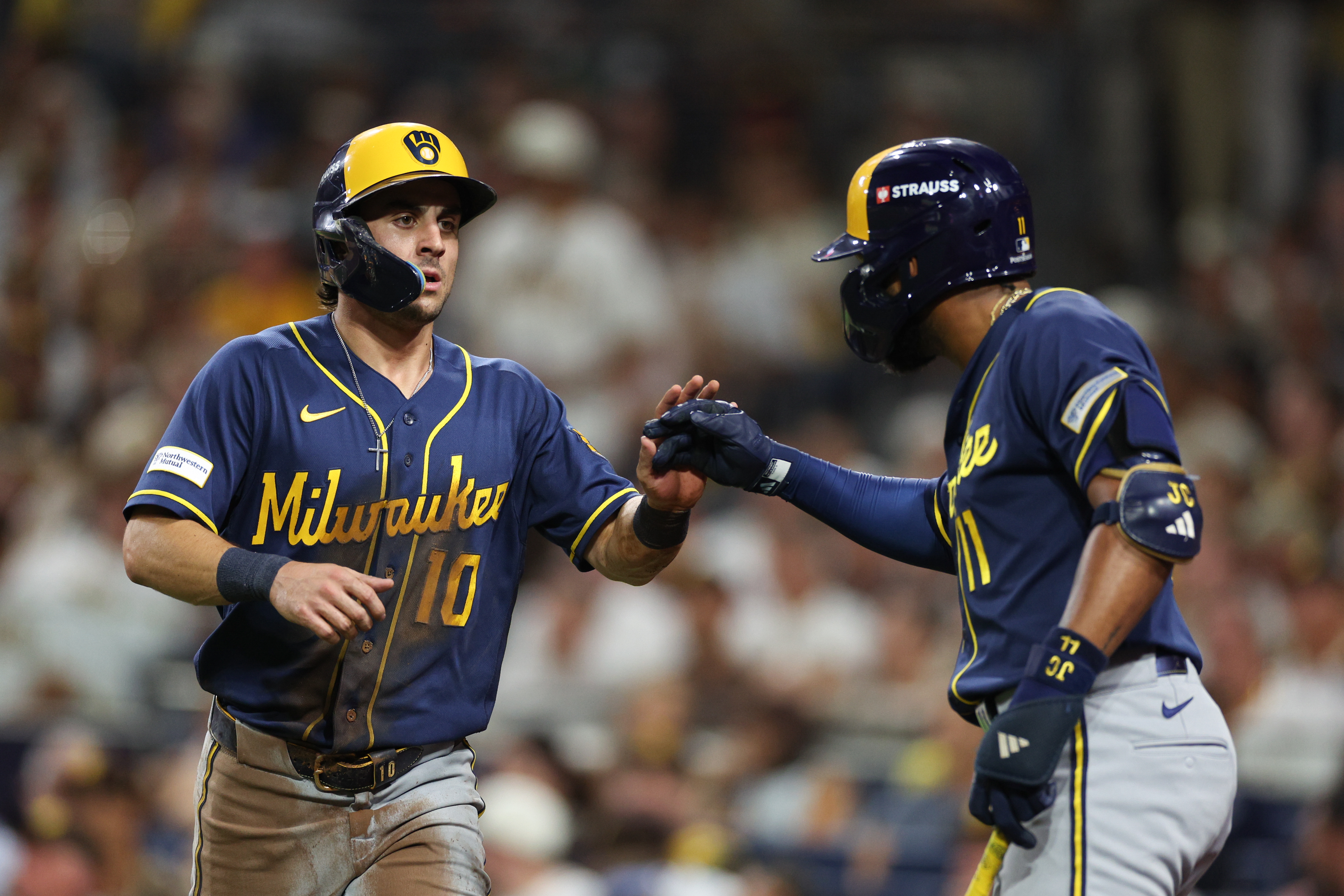 Milwaukee Brewers' Sal Frelick (10) is congratulated by Jackson Chourio after scoring on a single by Garrett Mitchell during the third inning in Game 4 of baseball's National League Division Series against the San Diego Padres Wednesday, Oct. 7, 2026, in San Diego. 