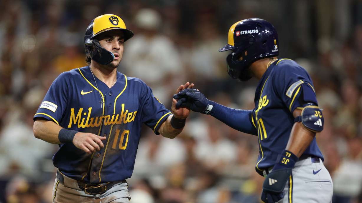 Milwaukee Brewers' Sal Frelick (10) is congratulated by Jackson Chourio after scoring on a single by Garrett Mitchell during the third inning in Game 4 of baseball's National League Division Series against the San Diego Padres Wednesday, Oct. 7, 2026, in San Diego.