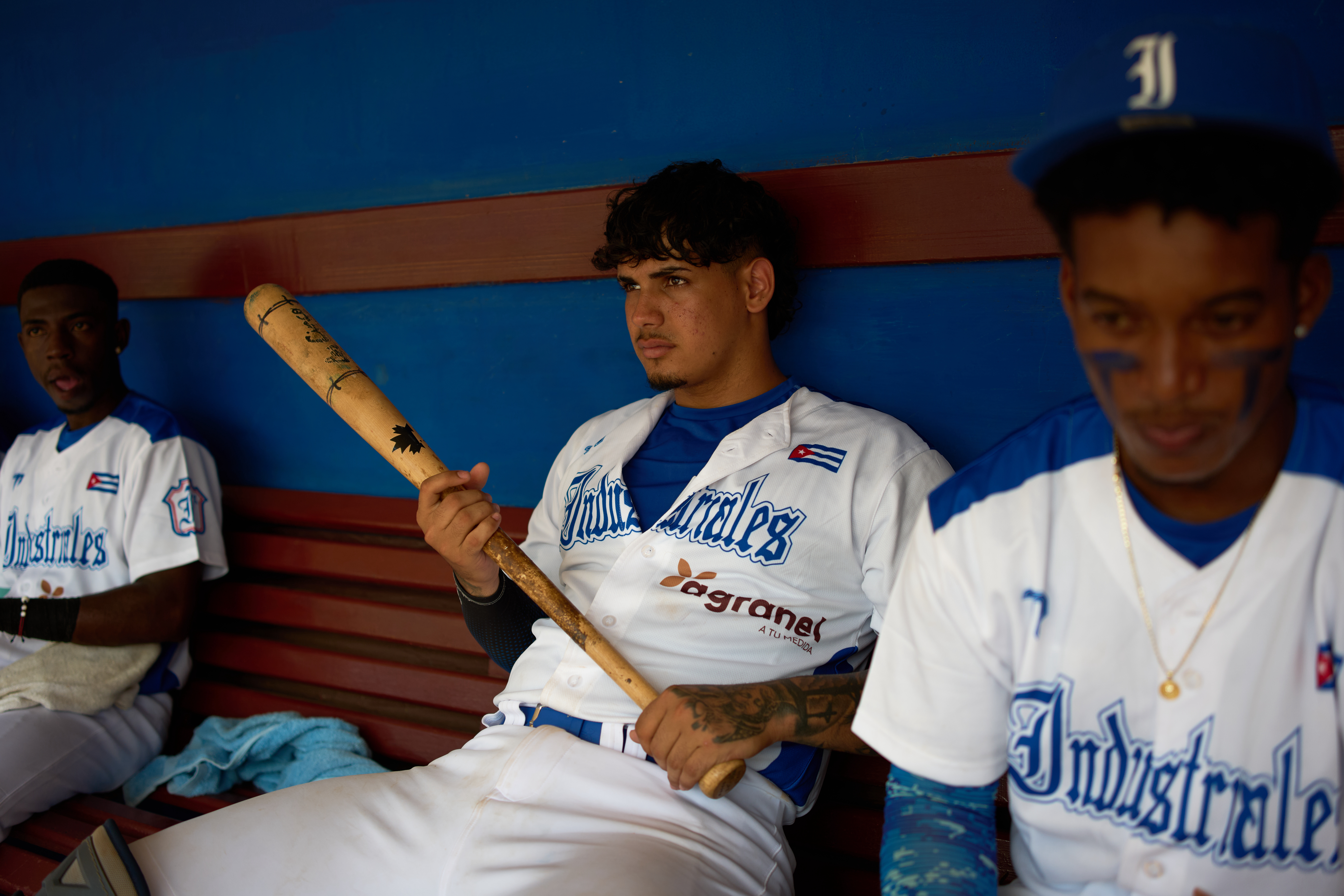 An Industriales player, wearing a jersey featuring a private sponsor logo, holds a baseball bat before a game against Pinar del Río in Havana, Cuba, Wednesday, Oct. 7, 2026. 