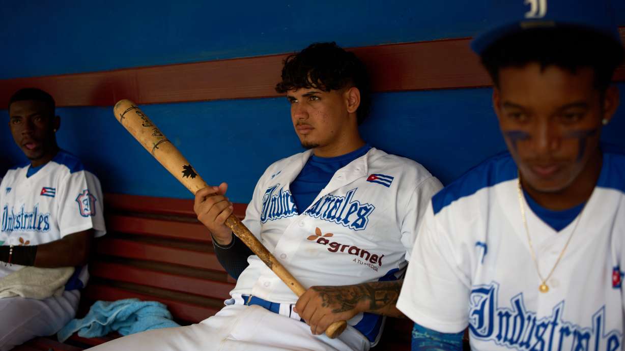 An Industriales player, wearing a jersey featuring a private sponsor logo, holds a baseball bat before a game against Pinar del Río in Havana, Cuba, Wednesday, Oct. 7, 2026.