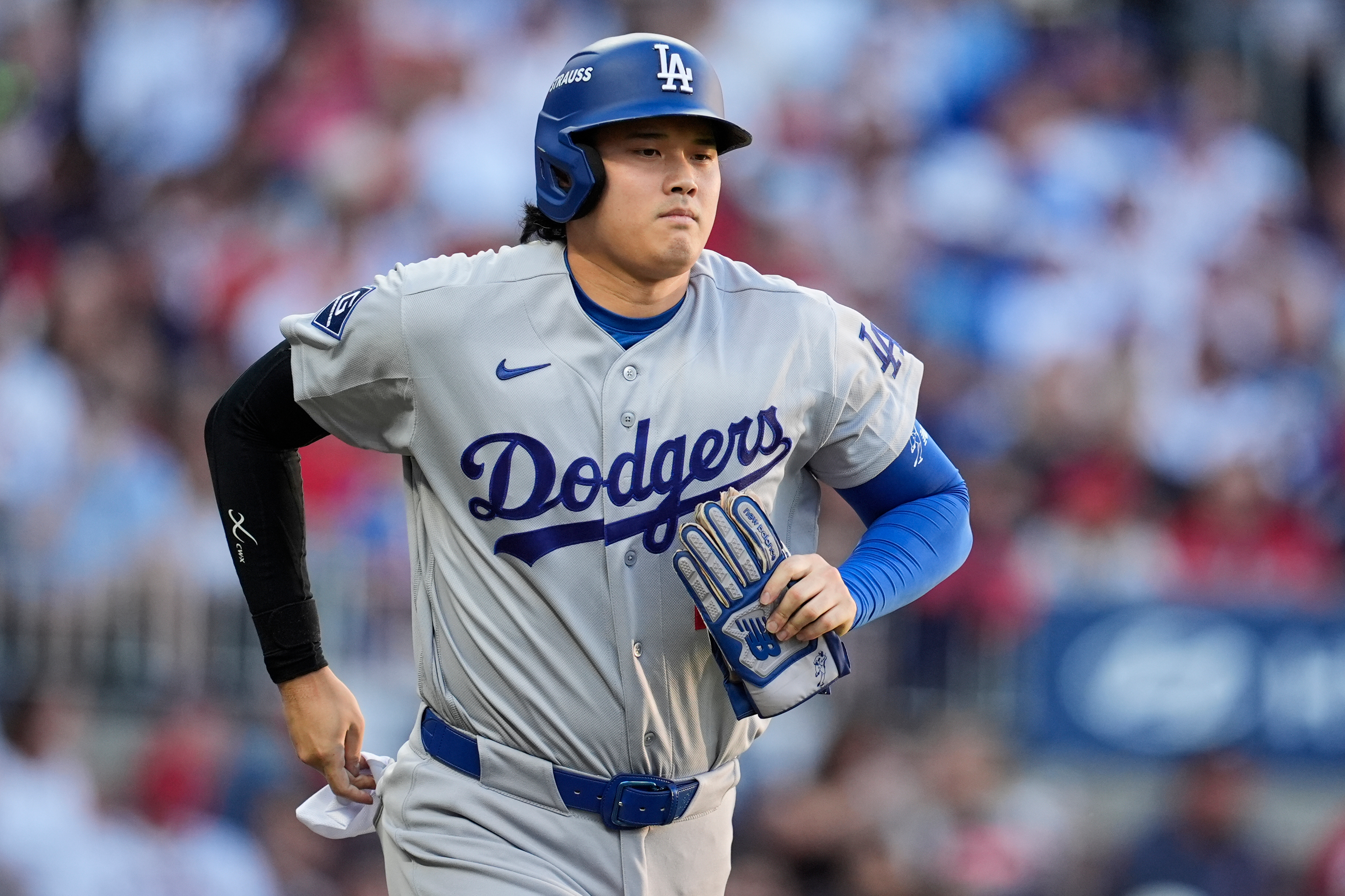 Los Angeles Dodgers two-way player Shohei Ohtani advances to first base on a walk during the second inning in Game 4 of baseball's National League Division Series against the Atlanta Braves, Wednesday, Oct. 7, 2026, in Atlanta. 