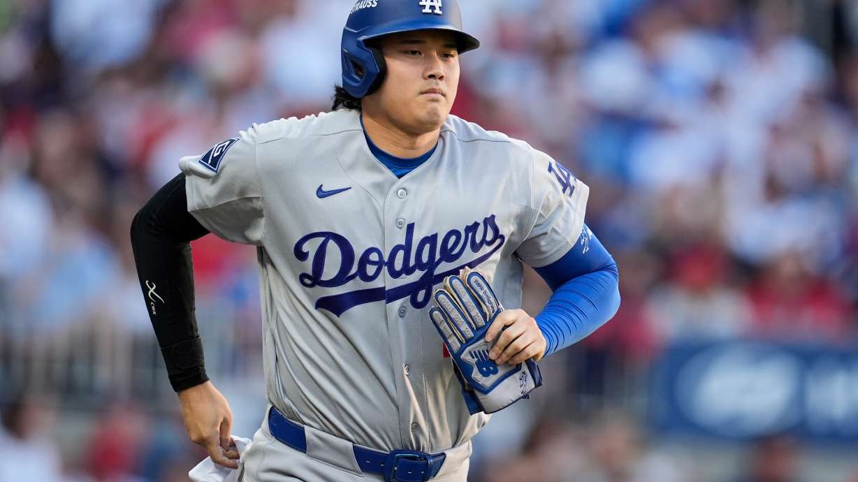 Los Angeles Dodgers two-way player Shohei Ohtani advances to first base on a walk during the second inning in Game 4 of baseball's National League Division Series against the Atlanta Braves, Wednesday, Oct. 7, 2026, in Atlanta.