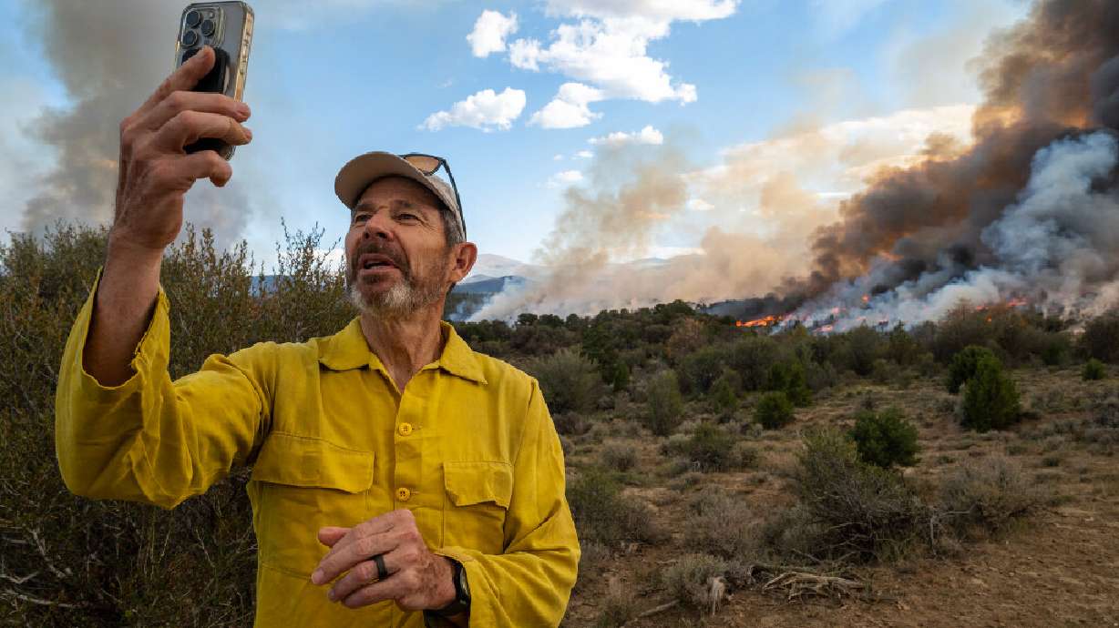 Sen. John Curtis (R-UT) does a short video with his phone as he makes a stop to observe as firefighters from the U.S. Forest Service conduct a prescribed burn in the mountains around Kinneys Peak and south of I-70 on Wednesday. Curtis visited the site in Richfield as he advocated for the Wildfire Emissions Prevention Act, a bill aimed at helping states prevent wildfires.