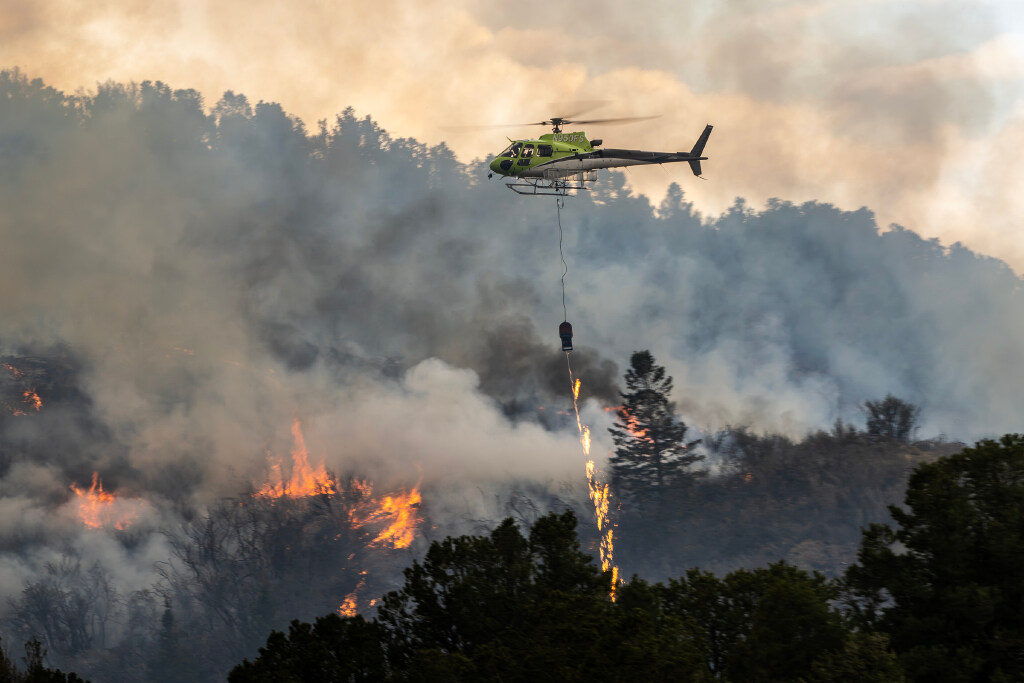 One of two helicopters equipped with a helitorch drops fire on sections of the mountain as the U.S. Forest Service conducts a prescribed burn in the mountains around Kinneys Peak and south of I-70 on Wednesday. Sen. John Curtis, R-Utah, made a stop to observe the work.