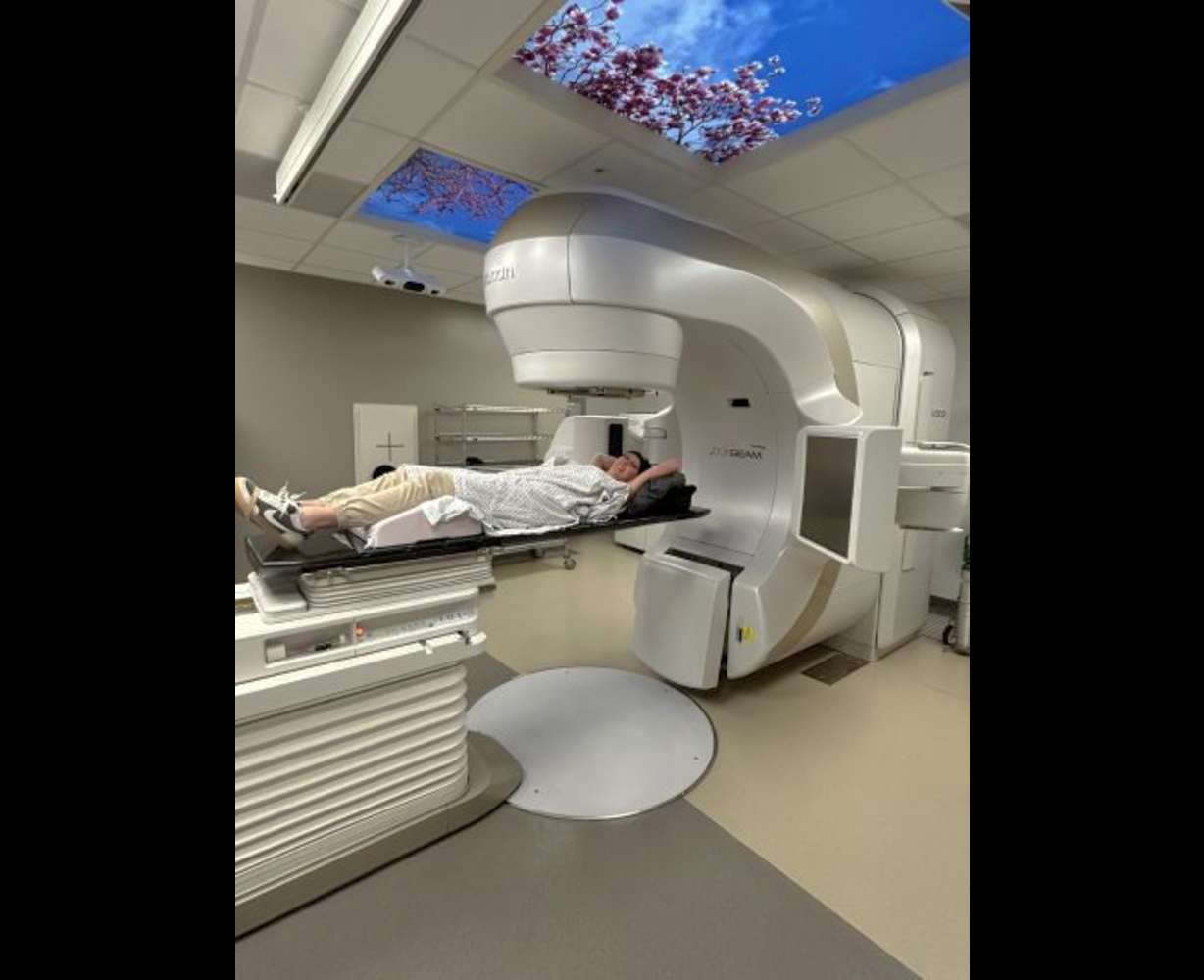 Dani Kurtz lies under a Varian TrueBeam linear accelerator in an undated photo.