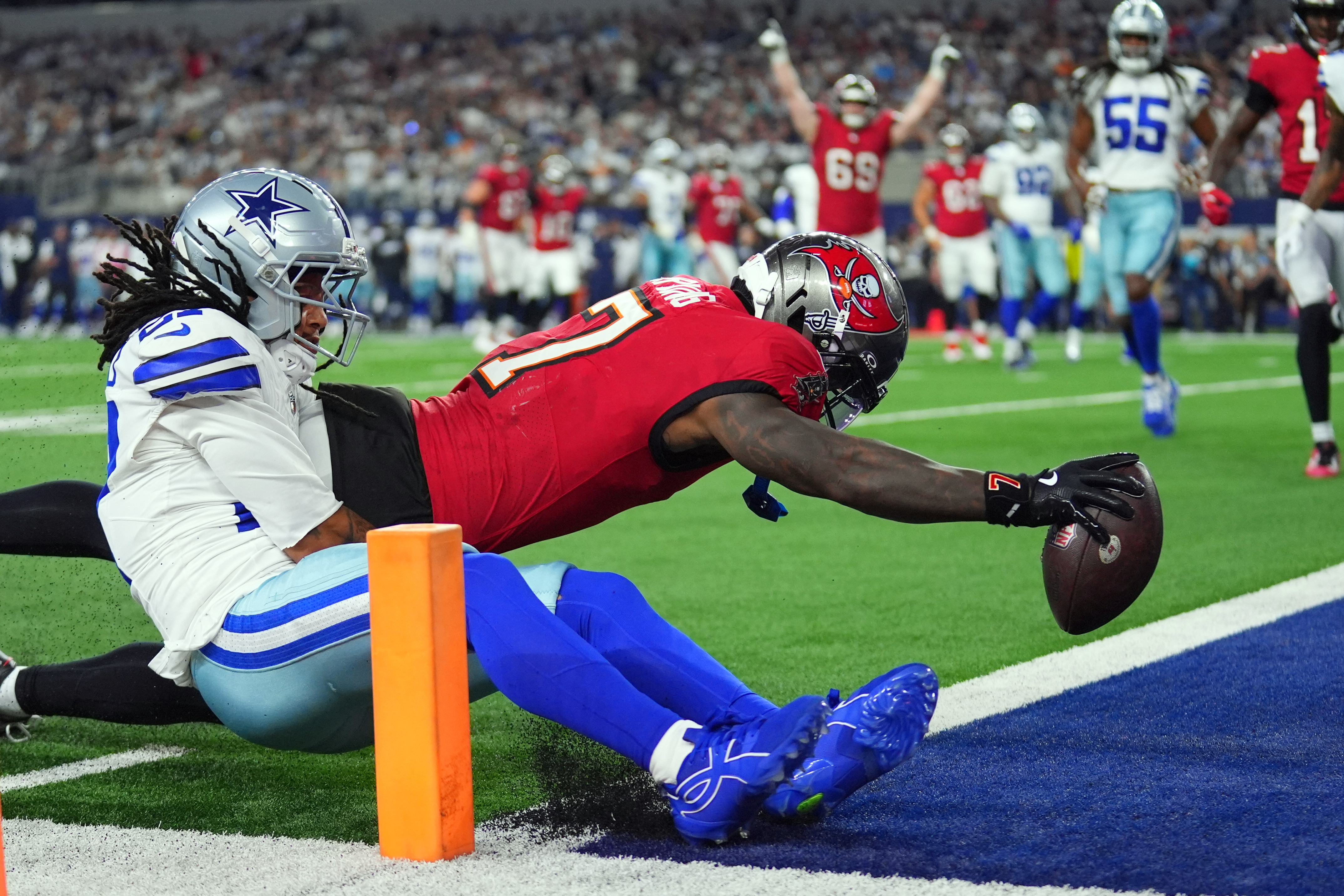 Tampa Bay Buccaneers running back Bucky Irving (7) dives past Dallas Cowboys defensive back Reddy Steward (27) for a touchdown in the first half of an NFL football game in Arlington, Texas on Thursday, Oct. 8, 2026. 