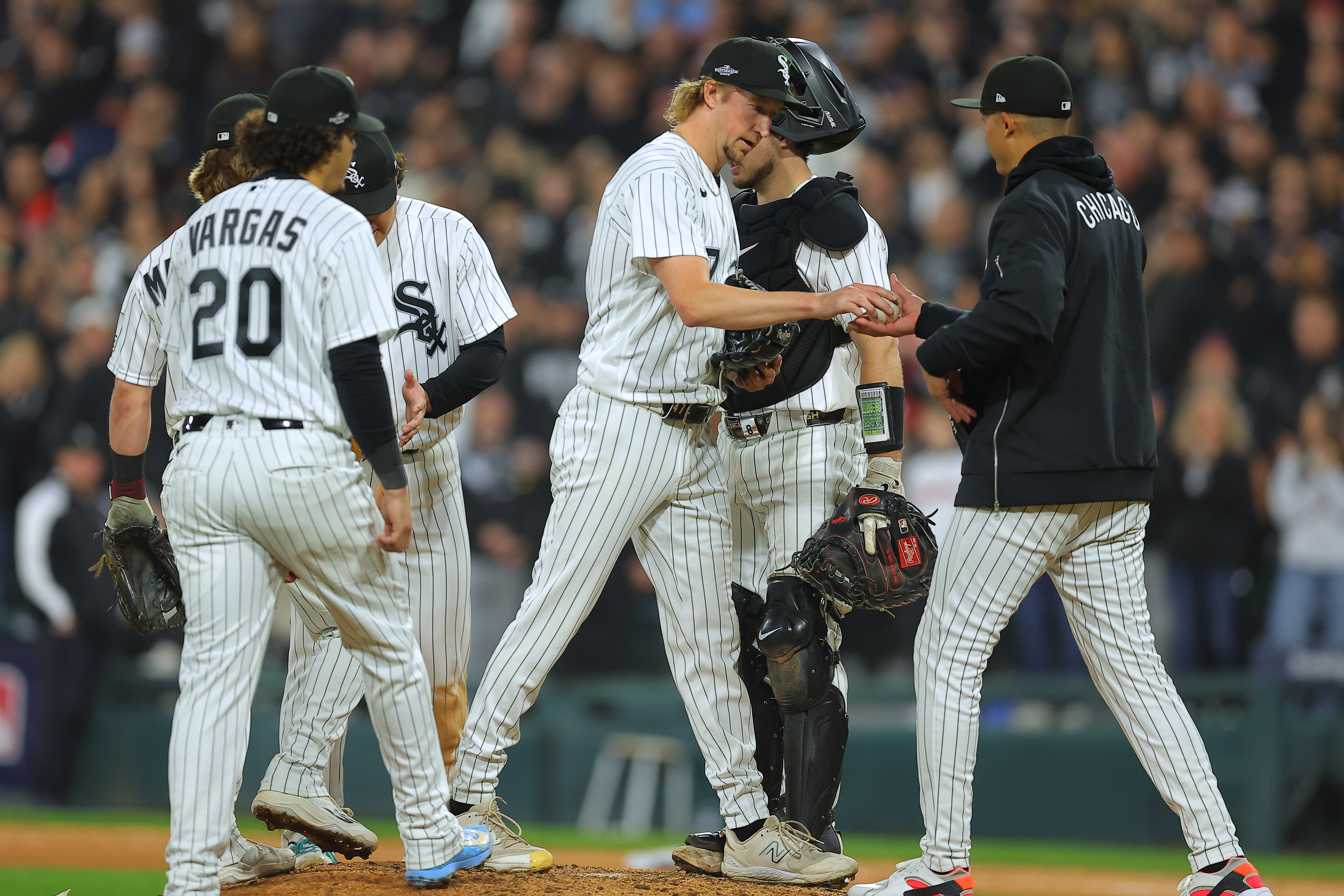 Chicago White Sox relief pitcher Erick Fedde, middle, hands the game ball to manager Will Venable, right, for a pitching change during the fifth inning of Game 4 of baseball's American League Division Series against the Cleveland Guardians, Thursday, Oct. 8, 2026, in Chicago. 