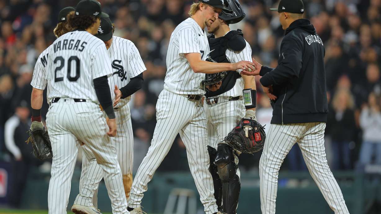 Chicago White Sox relief pitcher Erick Fedde, middle, hands the game ball to manager Will Venable, right, for a pitching change during the fifth inning of Game 4 of baseball's American League Division Series against the Cleveland Guardians, Thursday, Oct. 8, 2026, in Chicago.