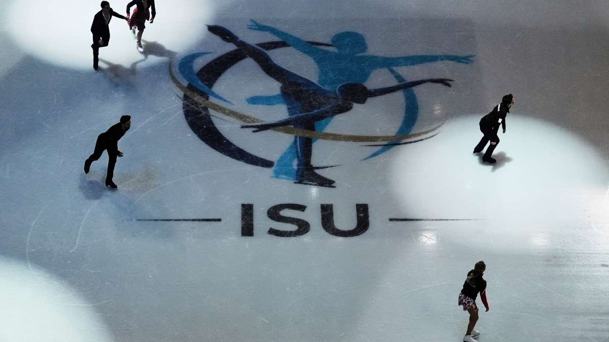 FILE - Skaters warm up before performing during the ice dance rhythm dance program at the figure skating world championships, Friday, March 28, 2025, in Boston.