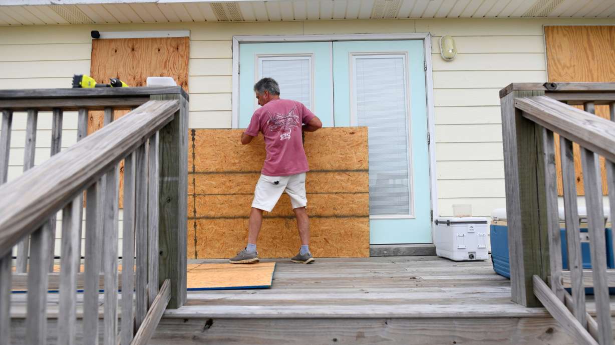 Larry Smith boards up his home with plywood ahead of Hurricane Isaias' expected landfall along the Gulf Coast in Dauphin Island, Ala., Thursday. Isaias strengthened into a Category 3 storm on Friday.