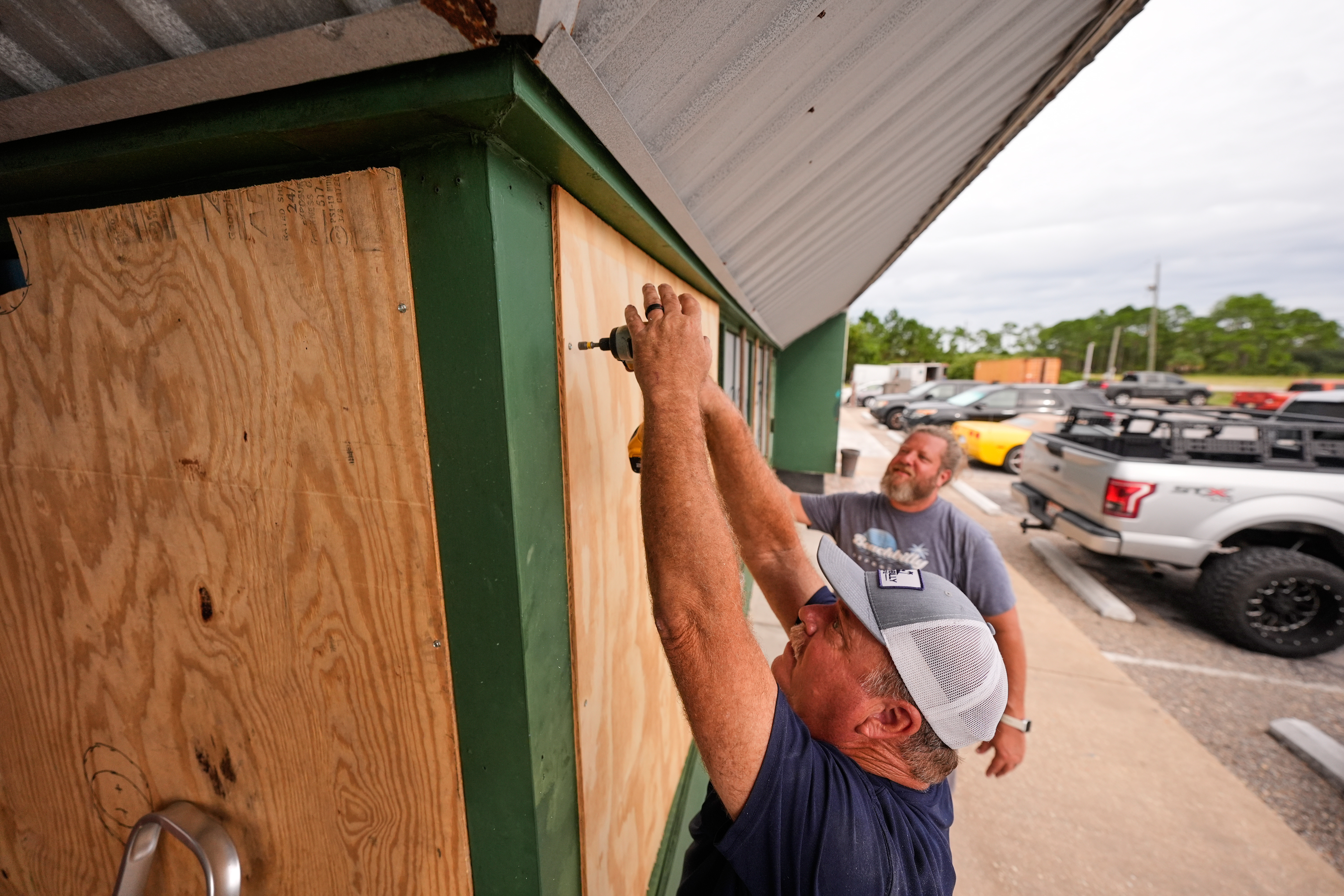 Mike Howard and Joshua Brown board up Perdido Key Sports Bar as Hurricane Isaias approaches Perdido Key, Fla., Thursday. The storm was closing in on the Gulf Coast as a Category 3 hurricane on Friday.