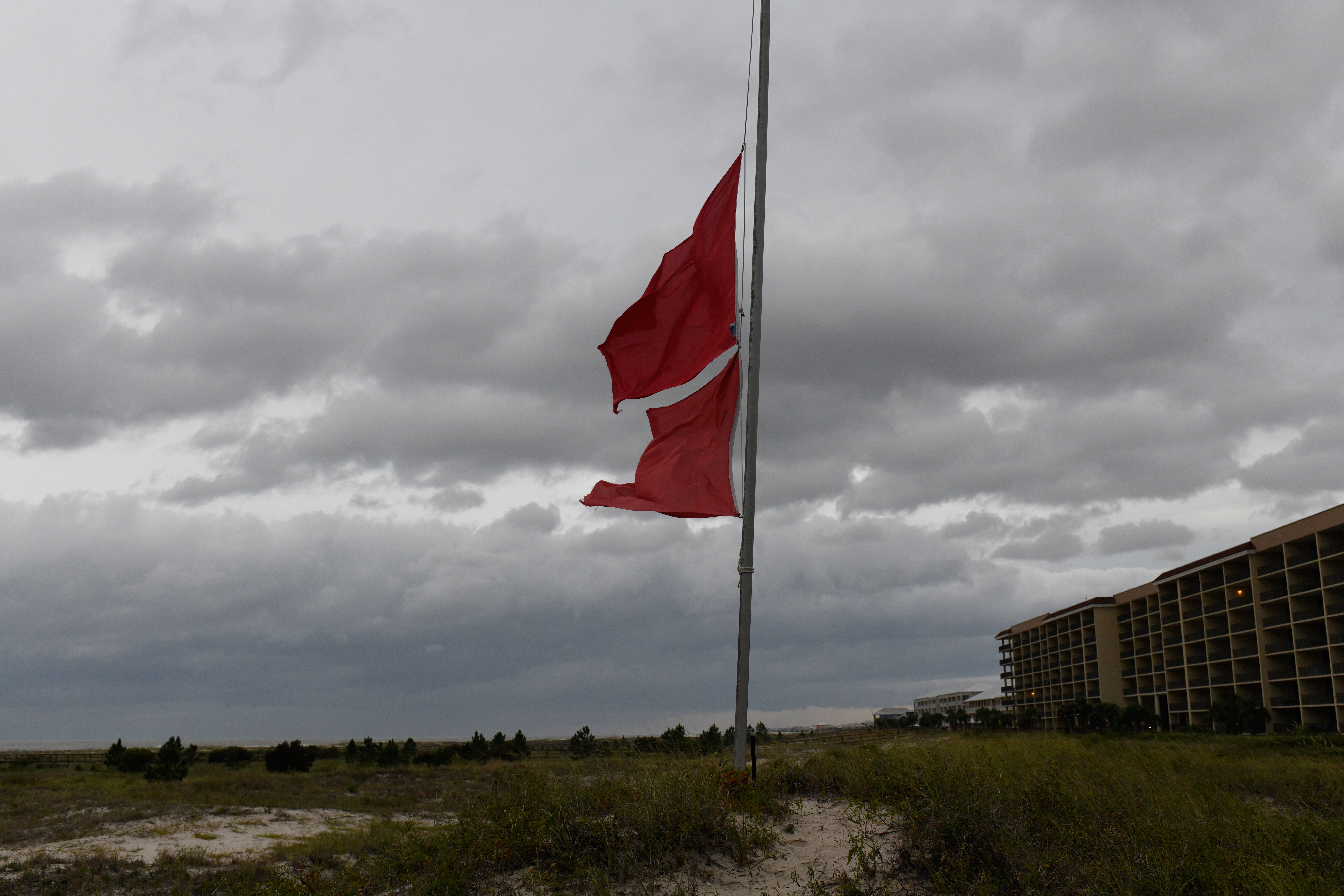 Marine flags flap in the wind as ominous clouds loom overhead on Friday, in Dauphin Island, Ala. Hurricane Isaias was closing in on the Gulf Coast as a Category 3 storm.