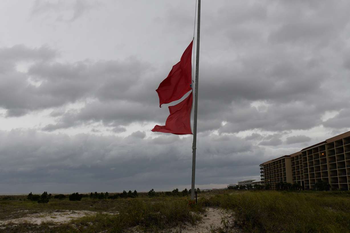 Marine flags flap in the wind as ominous clouds loom overhead on Friday, in Dauphin Island, Ala. Hurricane Isaias was closing in on the Gulf Coast as a Category 3 storm.