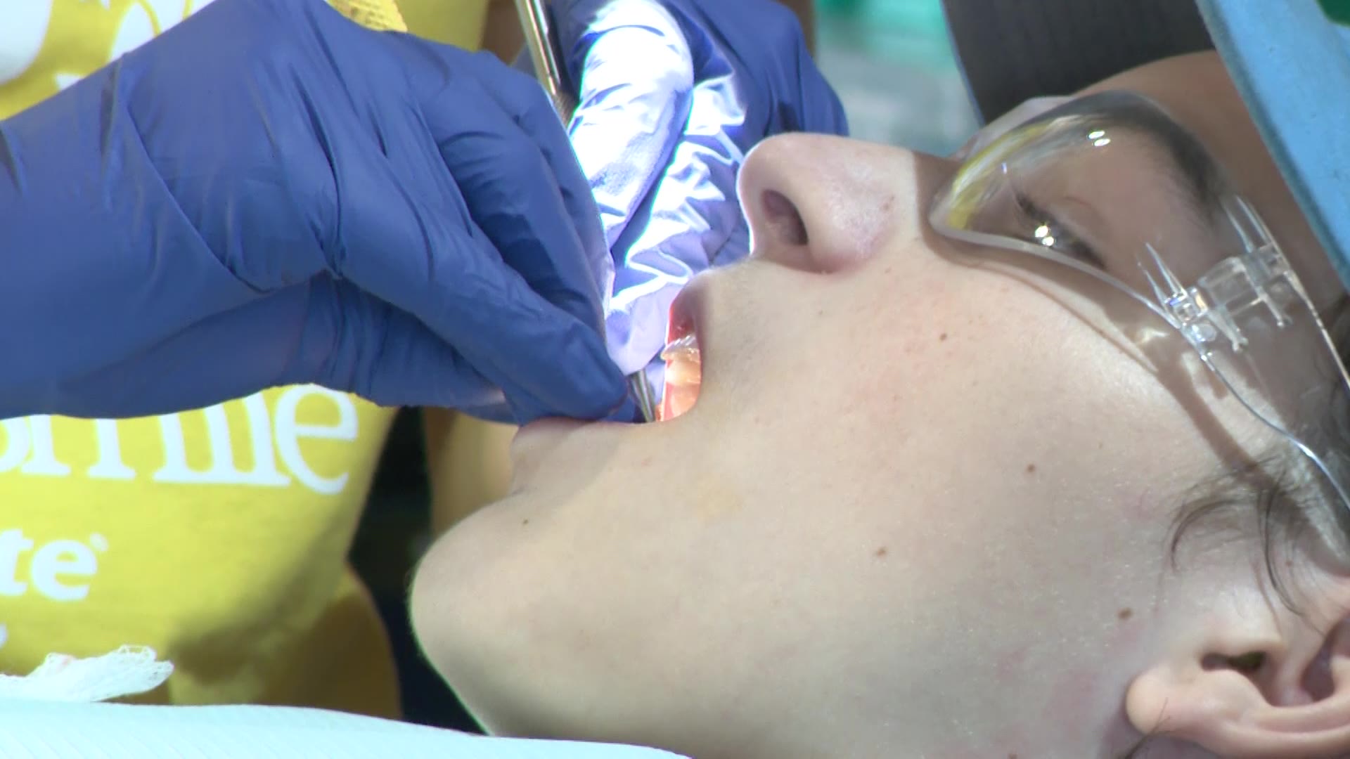 A child has their teeth cleaned during TeamSmile's free care event at America First Field, Friday. TeamSmile held an event to bring free dental care to underserved children and connect families with ongoing dental care.