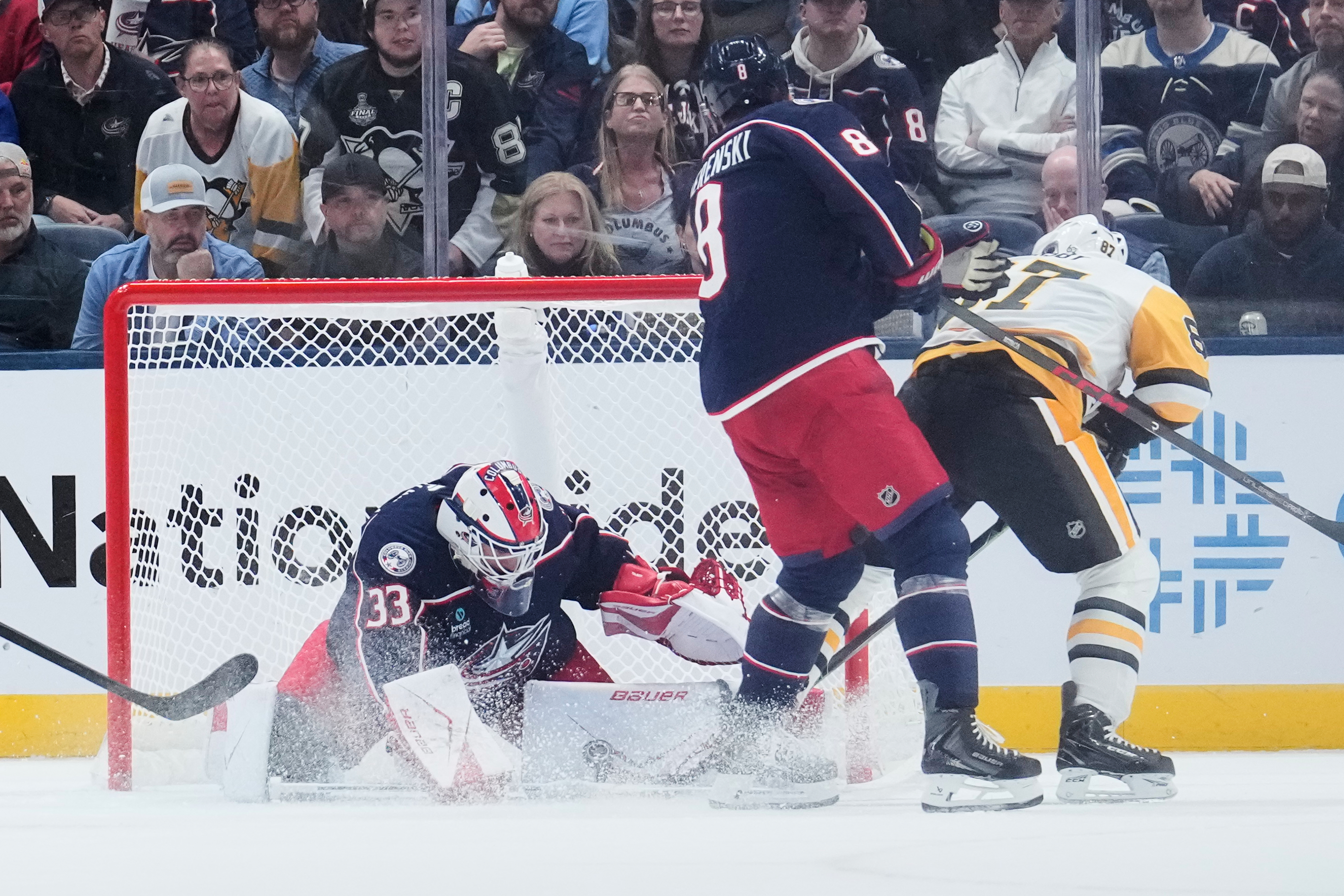 Columbus Blue Jackets goalie Cam Talbot (33) blocks a shot by Pittsburgh Penguins center Sidney Crosby (87), next to Zach Werenski (8), in overtime of an NHL hockey game in Columbus, Ohio, Friday, Oct. 9, 2026. 