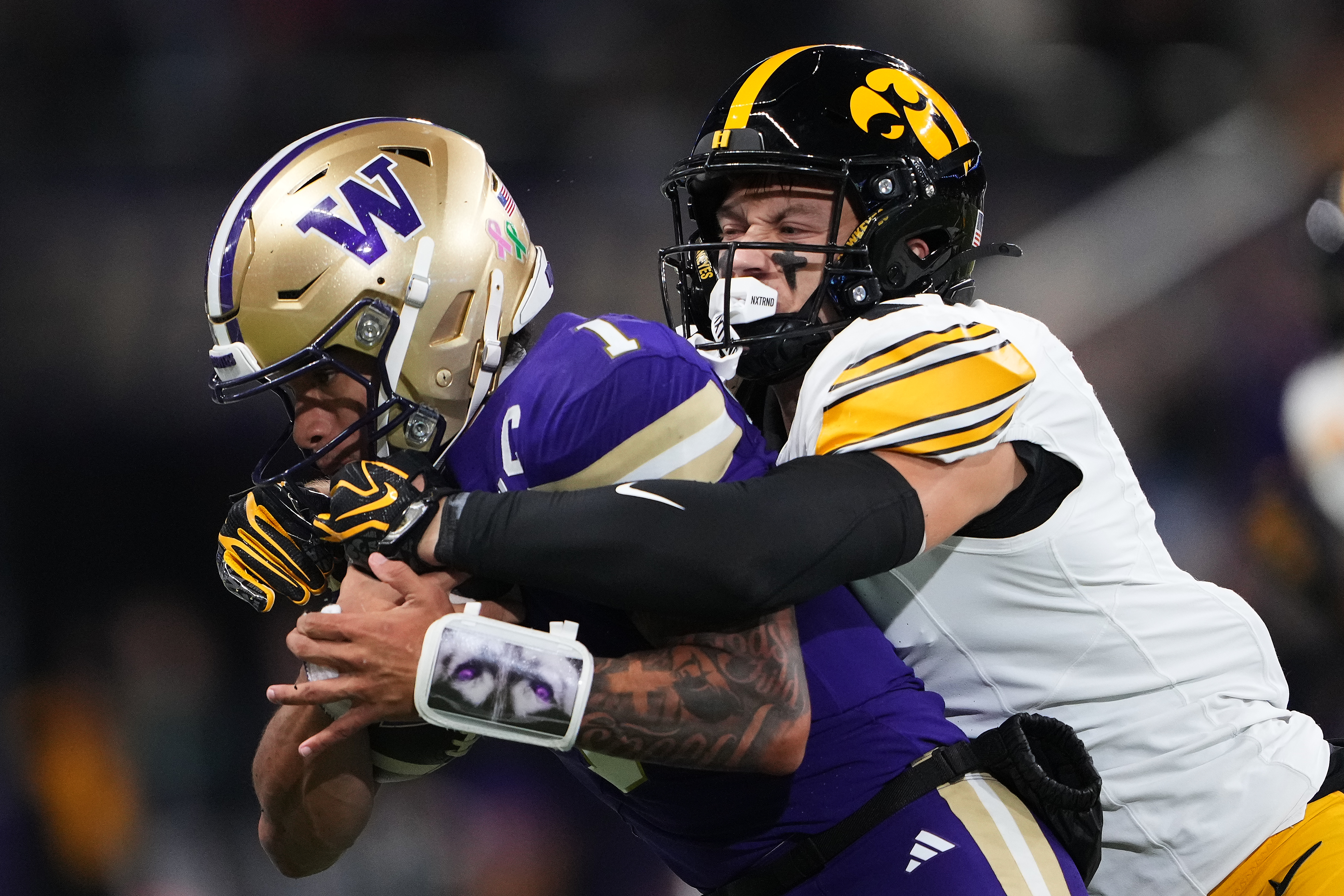 Iowa defensive back Zach Lutmer, right, tackled Washington quarterback Demond Williams Jr. during the first half of an NCAA college football game, Friday, Oct. 9, 2026, in Seattle. 