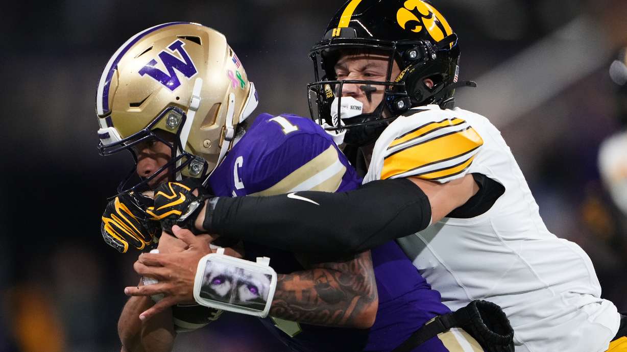 Iowa defensive back Zach Lutmer, right, tackled Washington quarterback Demond Williams Jr. during the first half of an NCAA college football game, Friday, Oct. 9, 2026, in Seattle.