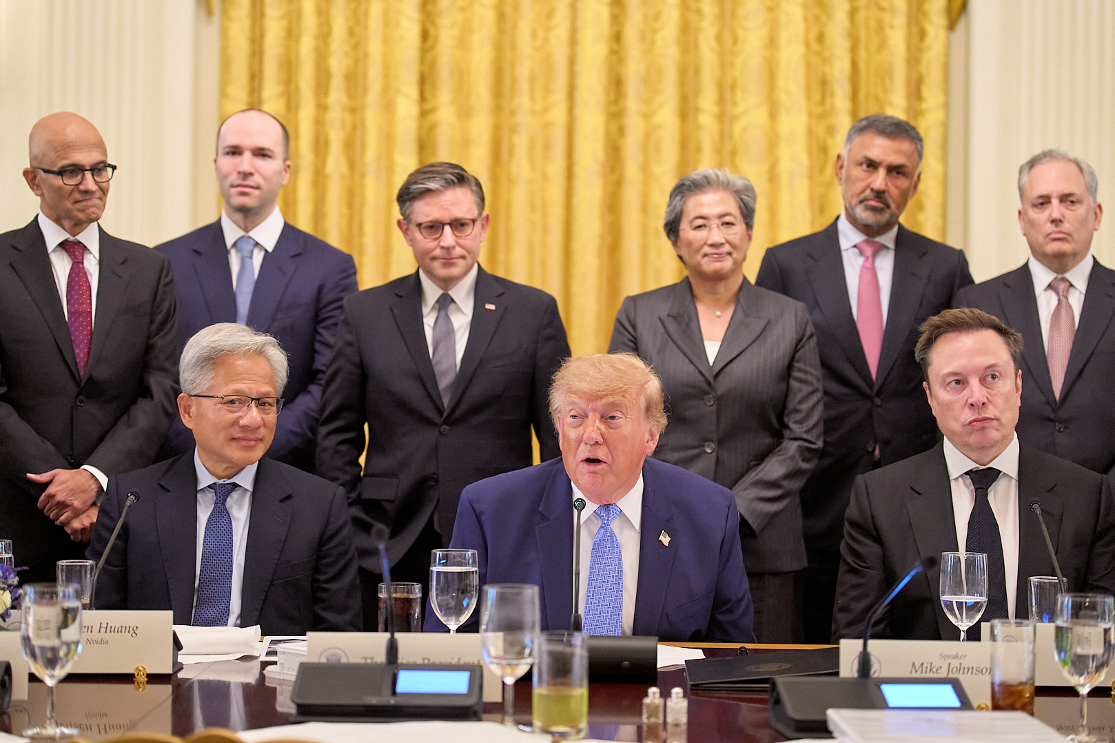 President Donald Trump, center, next to Nvidia CEO Jensen Huang, left, and Elon Musk, right, speaks in the East Room of the White House in Washington, Tuesday, Sept. 29, surrounded by top executives of AI firms including, from top left, Microsoft CEO Satya Nadella, Greg Brockman, President of OpenAI, House Speaker Mike Johnson, AMD CEO Lisa Su, Palo Alto Networks Chief Executive Nikesh Arora, and David Sacks.