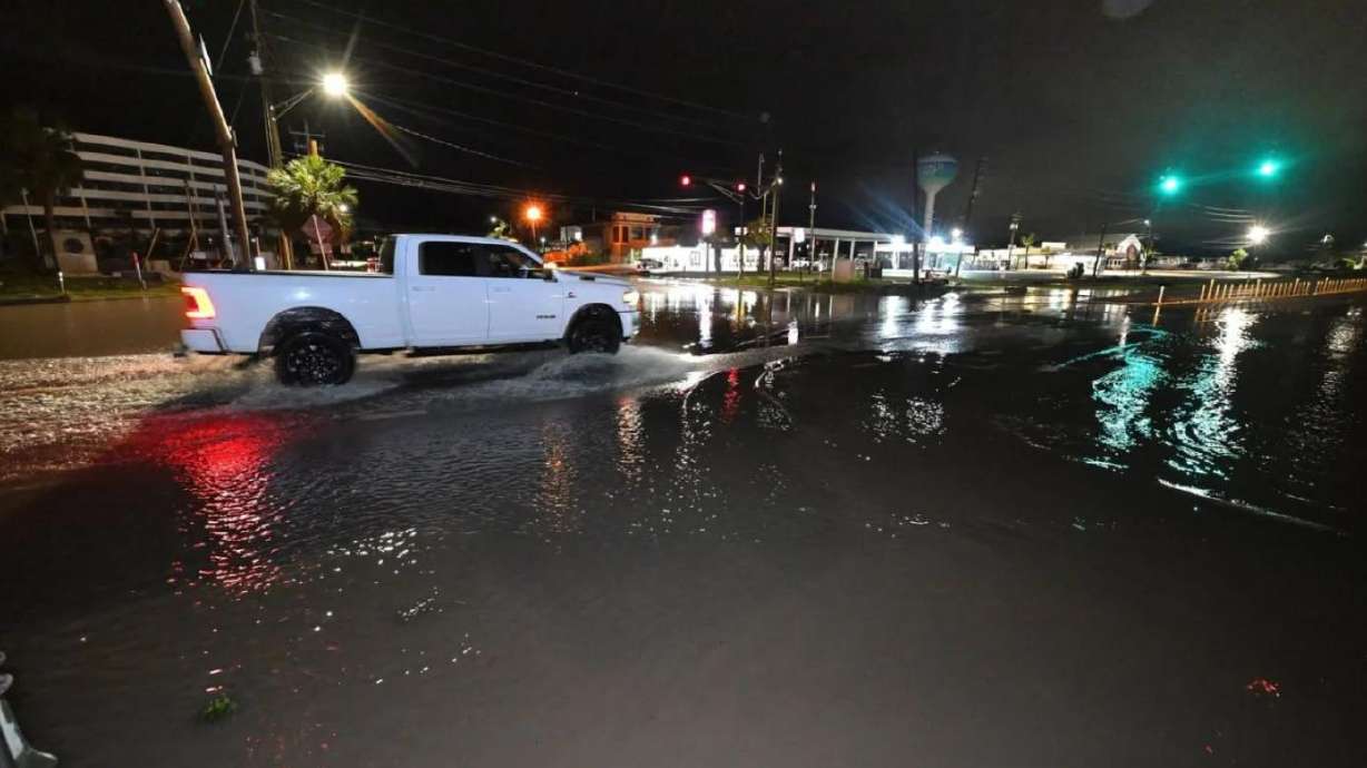 A motorist drives along a flooded road in Okaloosa County, Florida.