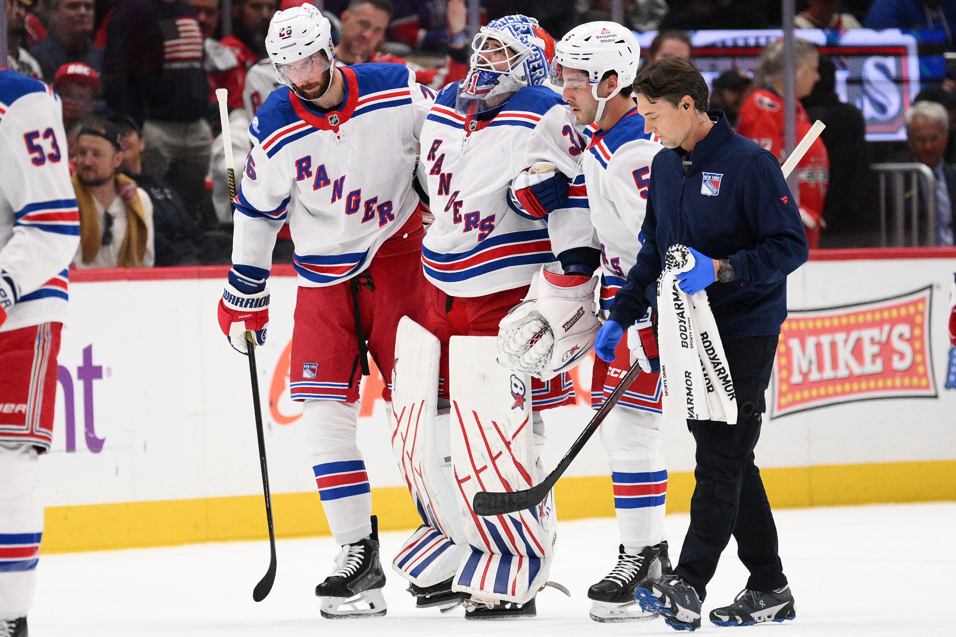 New York Rangers goaltender Igor Shesterkin, third from right, is helped to the bench after he was injured during the second period of an NHL hockey game against the Washington Capitals, Friday, Oct. 9, 2026, in Washington. 