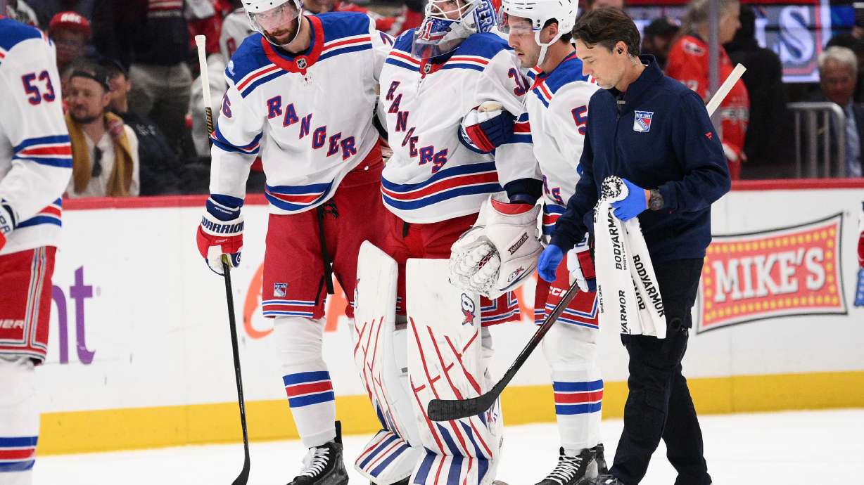 New York Rangers goaltender Igor Shesterkin, third from right, is helped to the bench after he was injured during the second period of an NHL hockey game against the Washington Capitals, Friday, Oct. 9, 2026, in Washington.