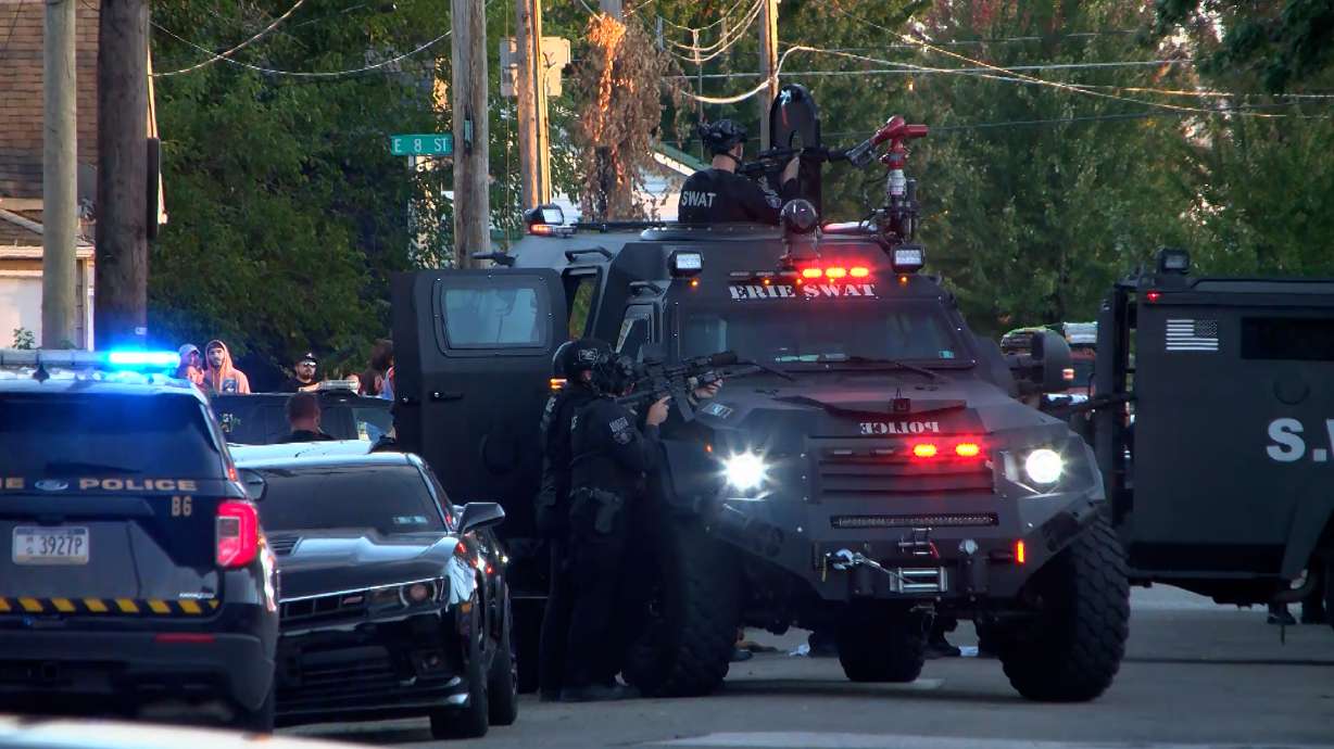 Police gather outside the scene of a shooting in Erie, Pa., on Friday evening. Authorities say a man killed eight people including a pregnant woman, children and other relatives at his home, and then took his own life.