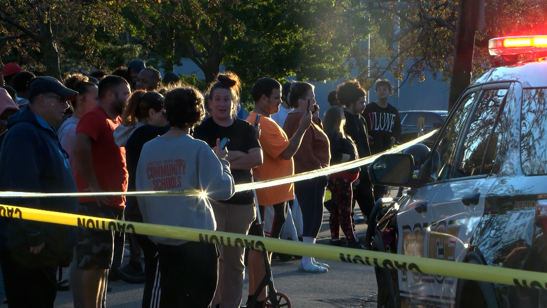 Bystanders gather outside the scene of a shooting in Erie, Pa., on Friday evening. Police on Saturday said two children and a pregnant woman are among the nine dead in the shooting.