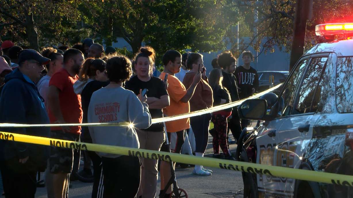 Bystanders gather outside the scene of a shooting in Erie, Pa., on Friday evening. Police on Saturday said two children and a pregnant woman are among the nine dead in the shooting.
