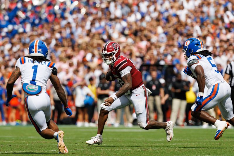 Oct 10, 2026; Gainesville, Florida, USA;  South Carolina Gamecocks quarterback LaNorris Sellers (16) runs with the ball while Florida Gators safety Bryce Thornton (1) and inside linebacker Myles Graham (5) attempt to tackle during the first half at Ben Hill Griffin Stadium.