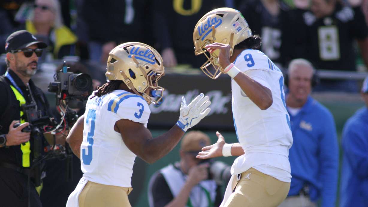 UCLA quarterback Nico Iamaleava (9) congratulates running back Wayne Knight (3) on a touchdown during the first half of an NCAA college football game against Oregon, Saturday, Oct. 10, 2026, in Eugene, Ore.