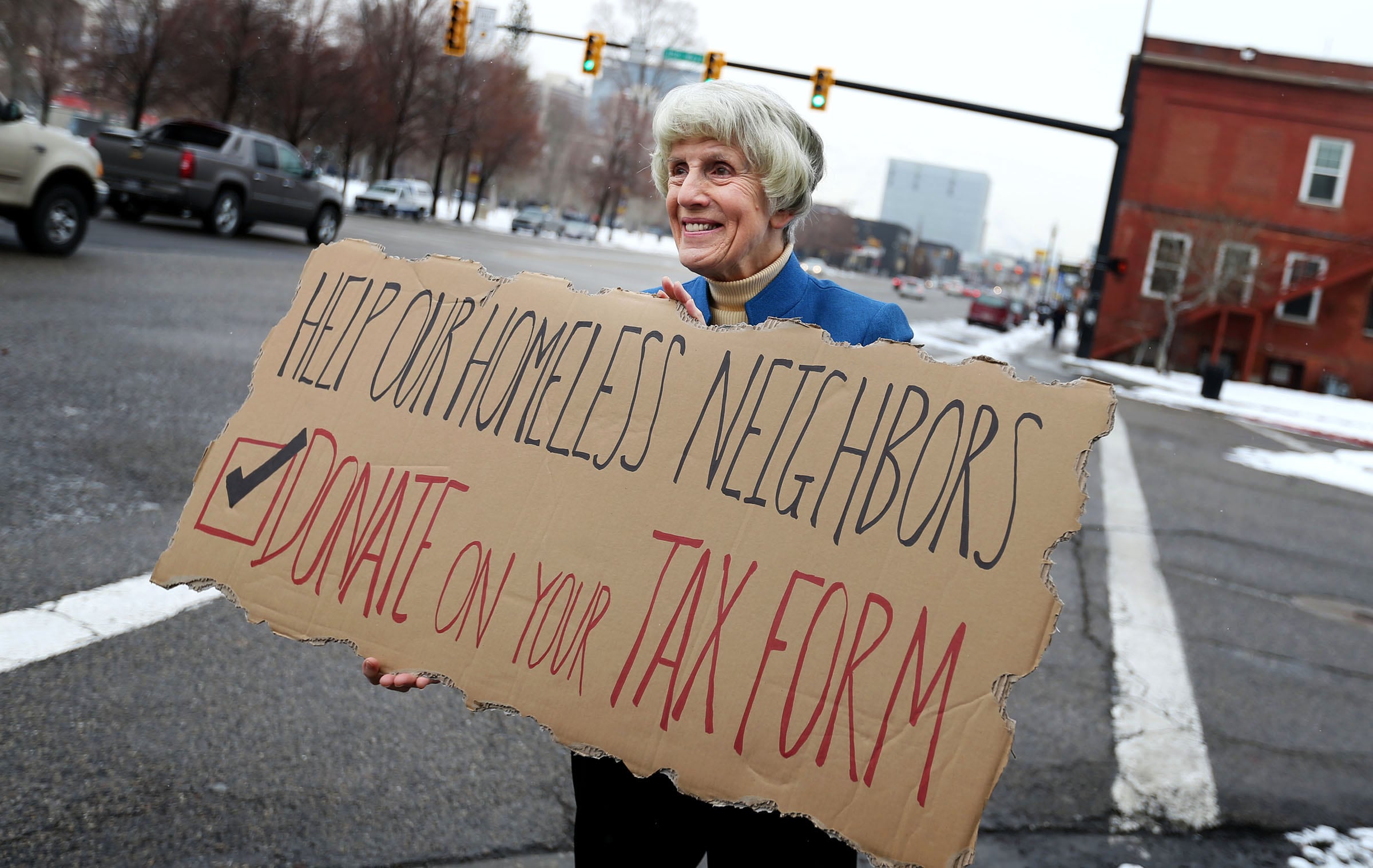 Homeless advocate Pamela Atkinson encourages passersby to support the Pamela Atkinson Homeless Trust Fund through donations on their tax forms while standing outside the Fourth Street Clinic in Salt Lake City on Feb. 4, 2016. Atkinson died on Saturday at the age of 93.