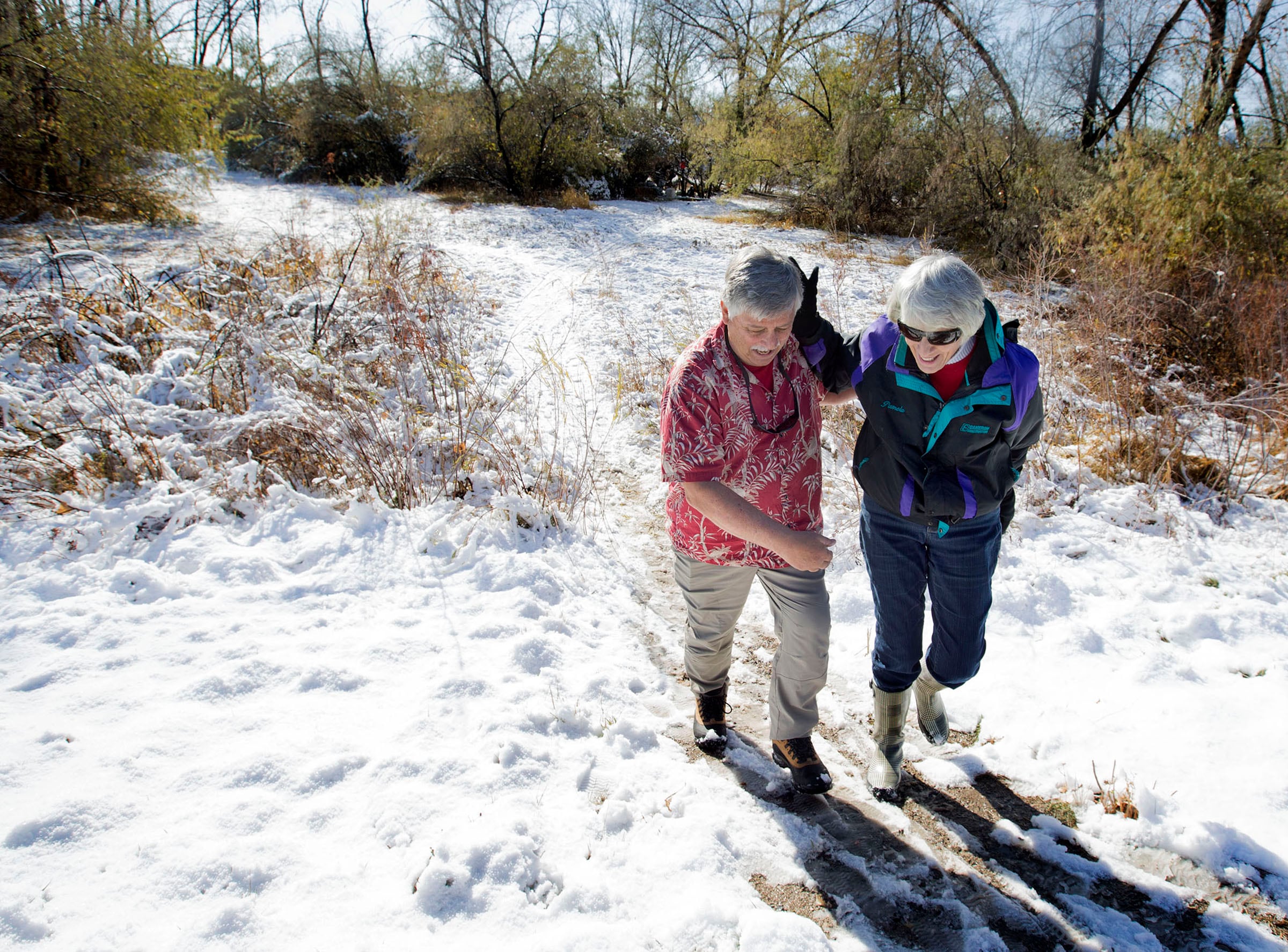 Ed Snoddy and Pamela Atkinson help each other up a slippery hill after delivering Thanksgiving meals to homeless people living in tents in West Valley City on Nov. 24, 2016. Atkinson died on Saturday at the age of 93.