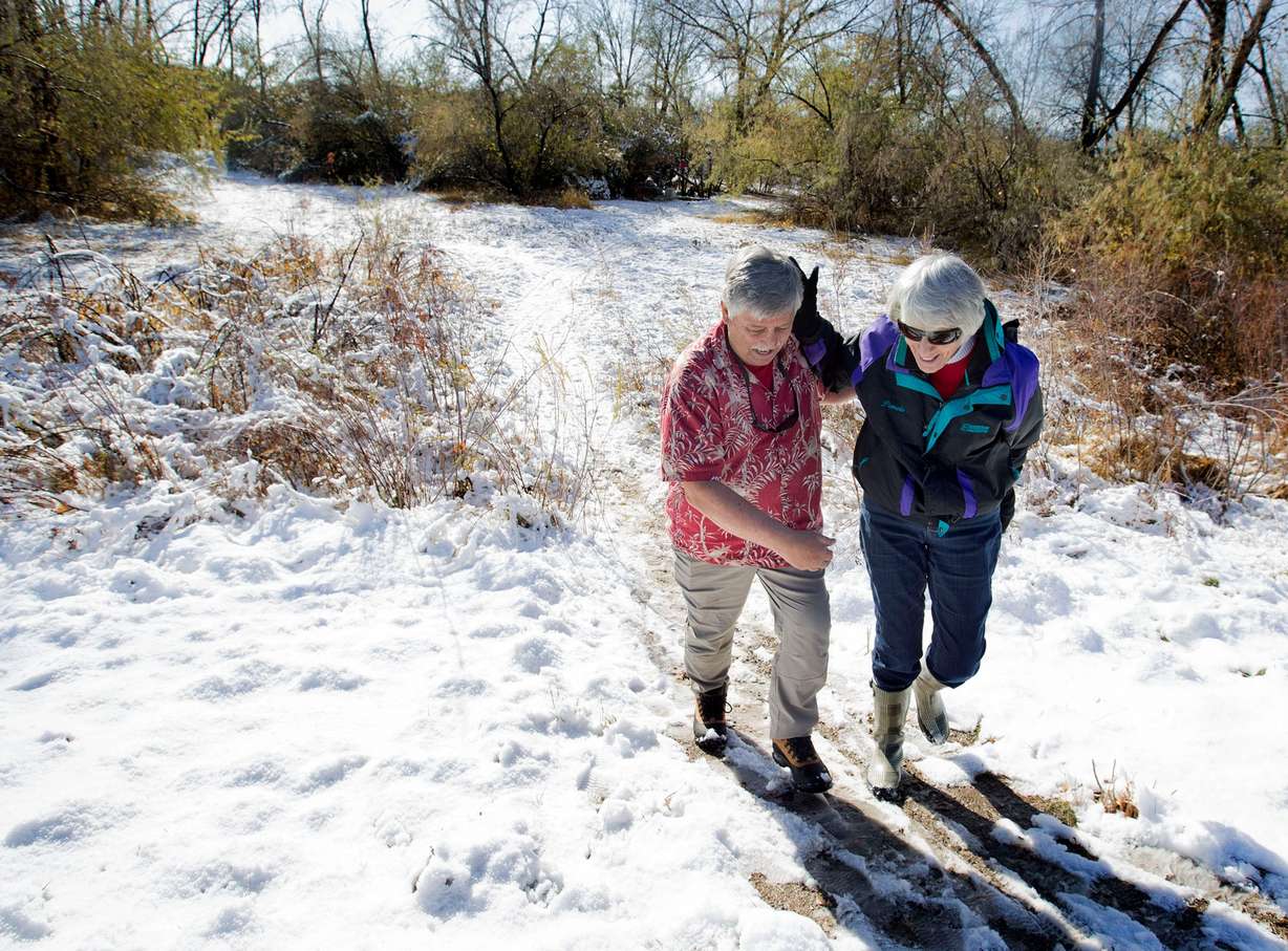 Ed Snoddy and Pamela Atkinson help each other up a slippery hill after delivering Thanksgiving meals to homeless people living in tents in West Valley City on Nov. 24, 2016. Atkinson died on Saturday at the age of 93.